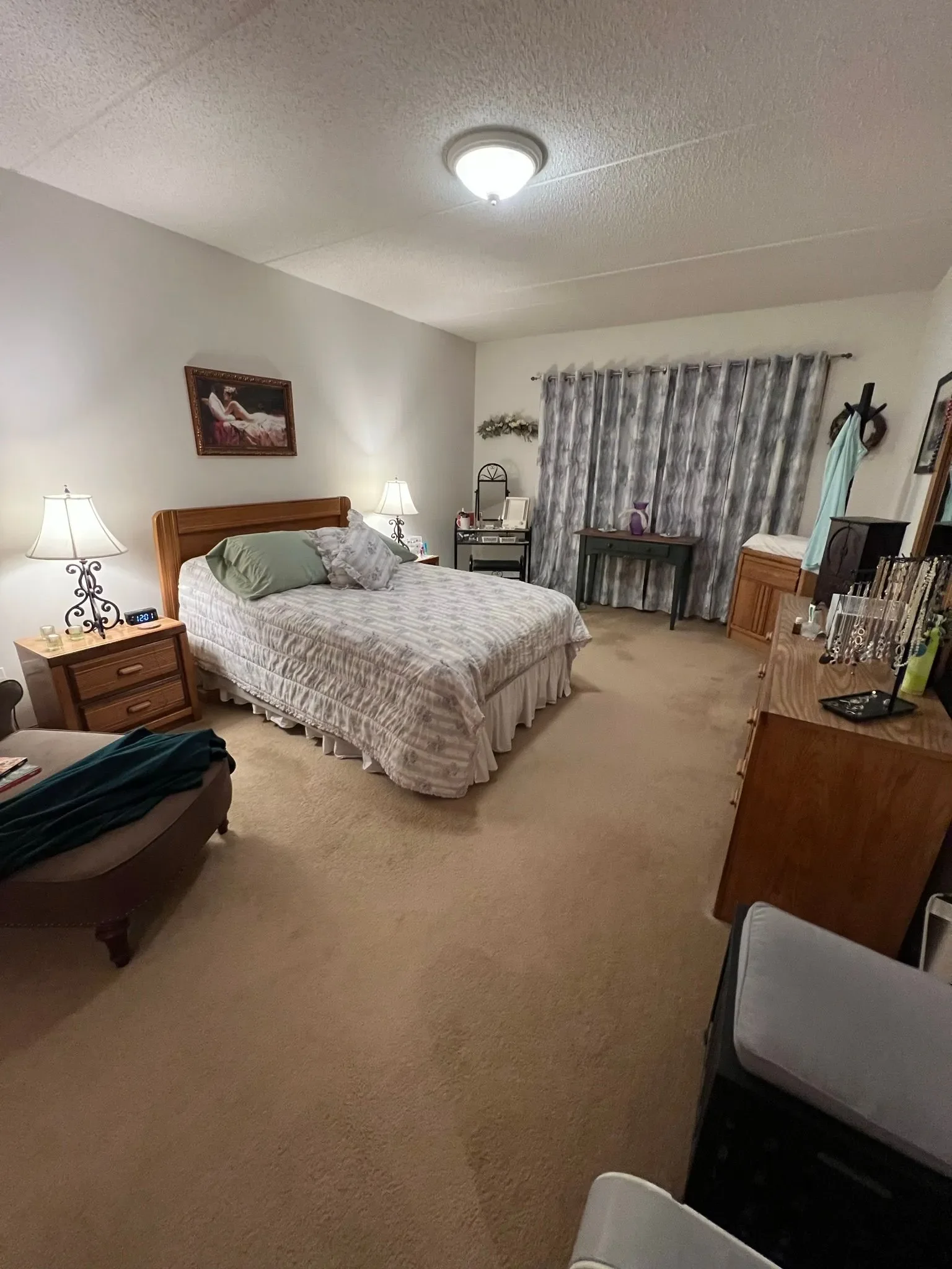 Old style bedroom as the before. Heavy on wood furniture and patterned blinds.