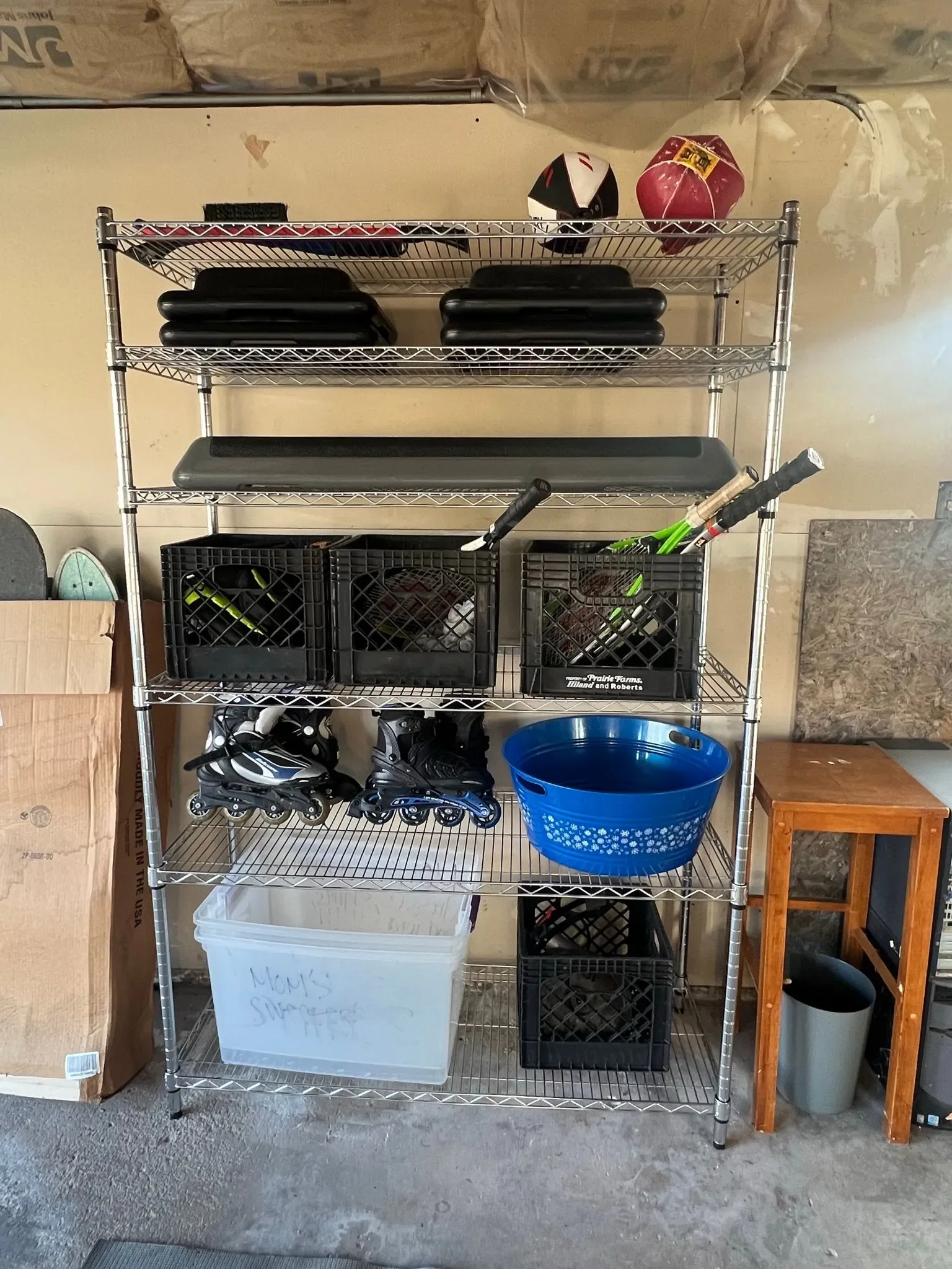 An organized garage shelving unit with sporting goods stacked efficiently