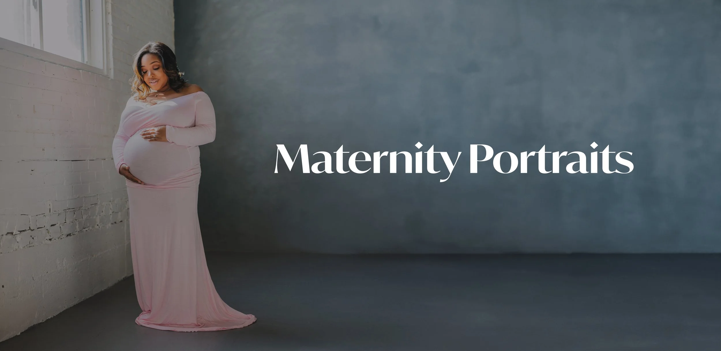 A pregnant woman in a long pink dress gently holding her belly, standing indoors by a window with white brick walls, with the words "Maternity Portraits" overlaid on the image.