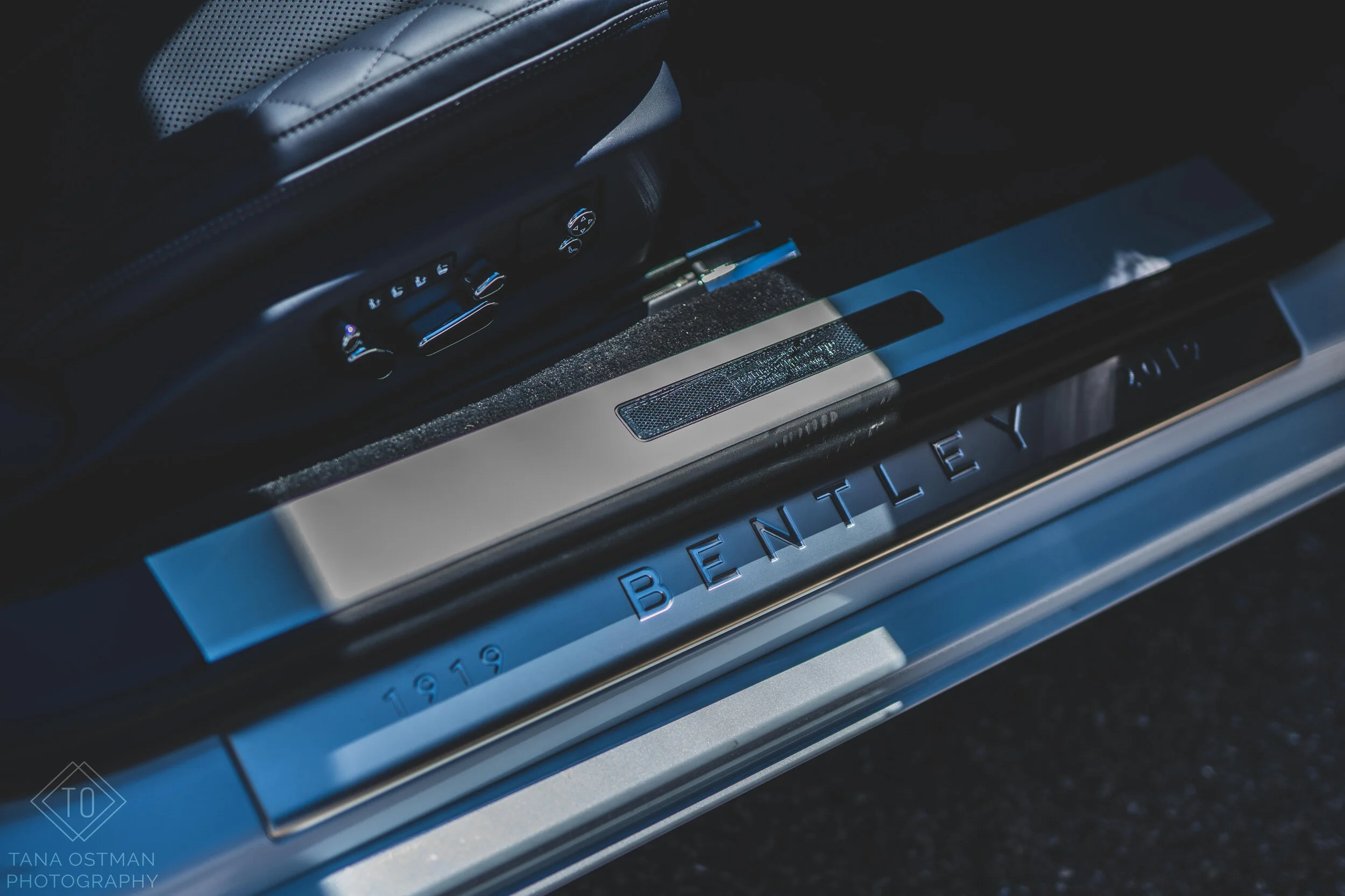 Close-up of the door sill of a Bentley car, showing the Bentley logo and the year 1919 engraved in metal.