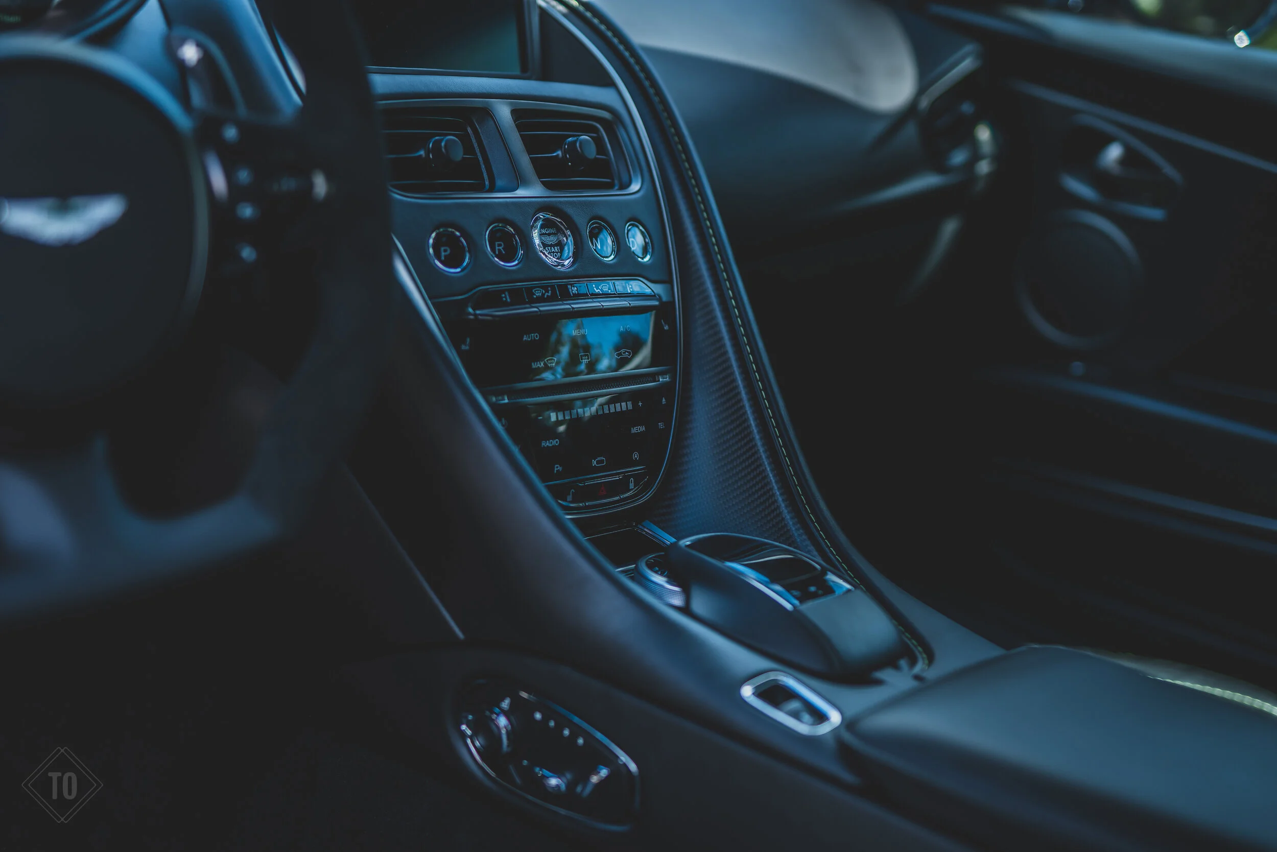 Interior of a luxury sports car with a sleek dashboard, steering wheel, and center console.