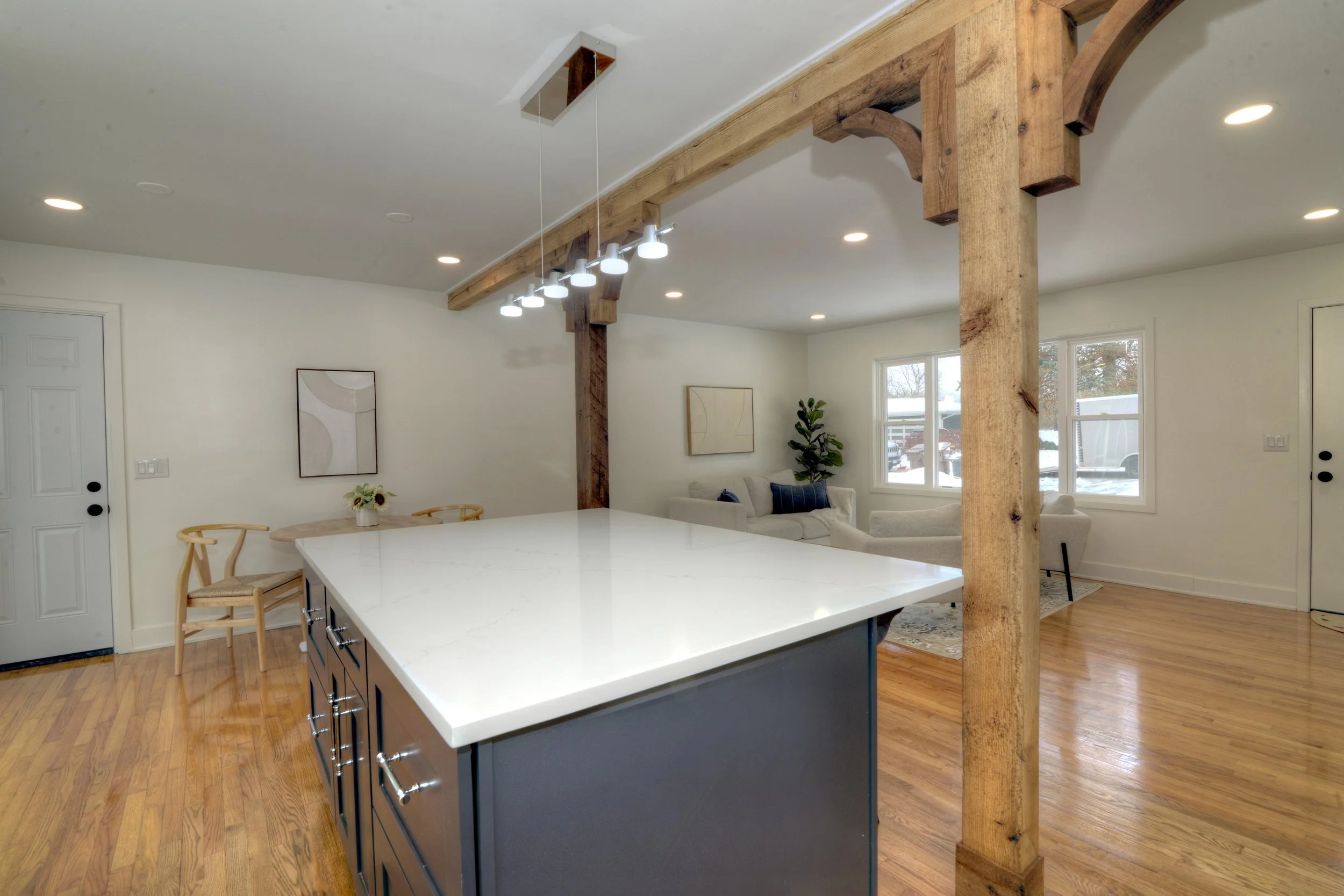 Modern kitchen island with quartz countertop, exposed wood beams, and open layout