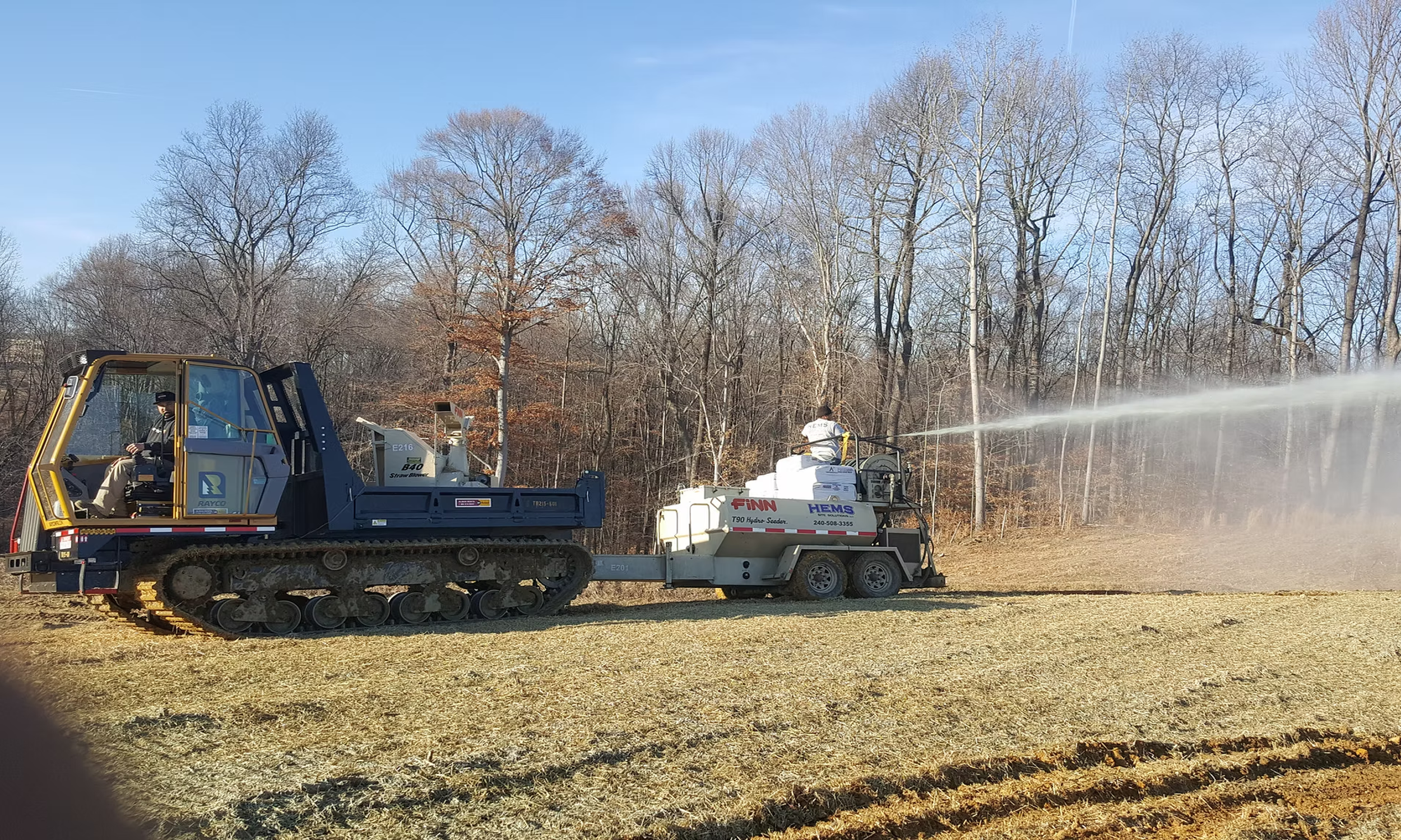 Hydroseeding equipment spraying slurry to establish ground cover for erosion and sediment control on a job site