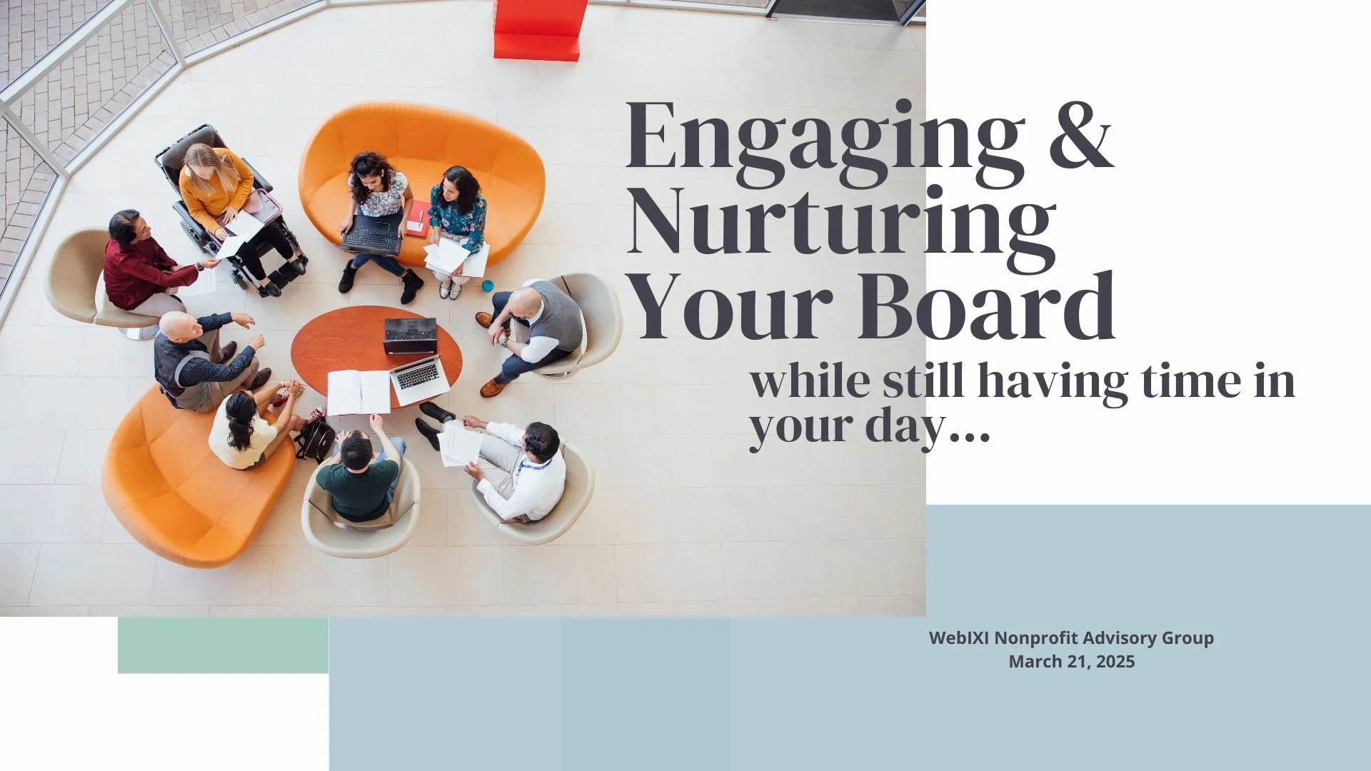 A group of diverse people sit around a circular table in a modern office space, engaging in a discussion with laptops, notebooks, and papers. The scene is viewed from above, showing colorful curved seating and a bright, open environment with large windows.