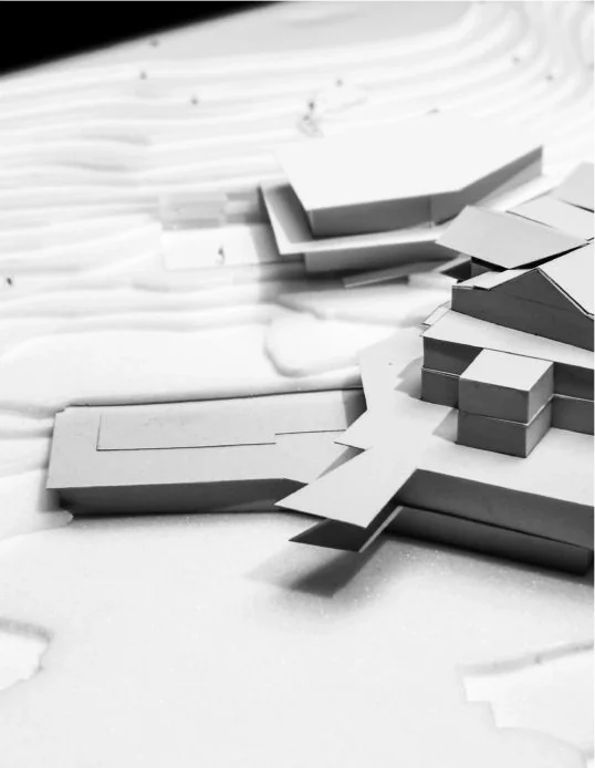 Architektonisches Modell aus weißen Pappe mit Gebäuden und Terrain-Details.