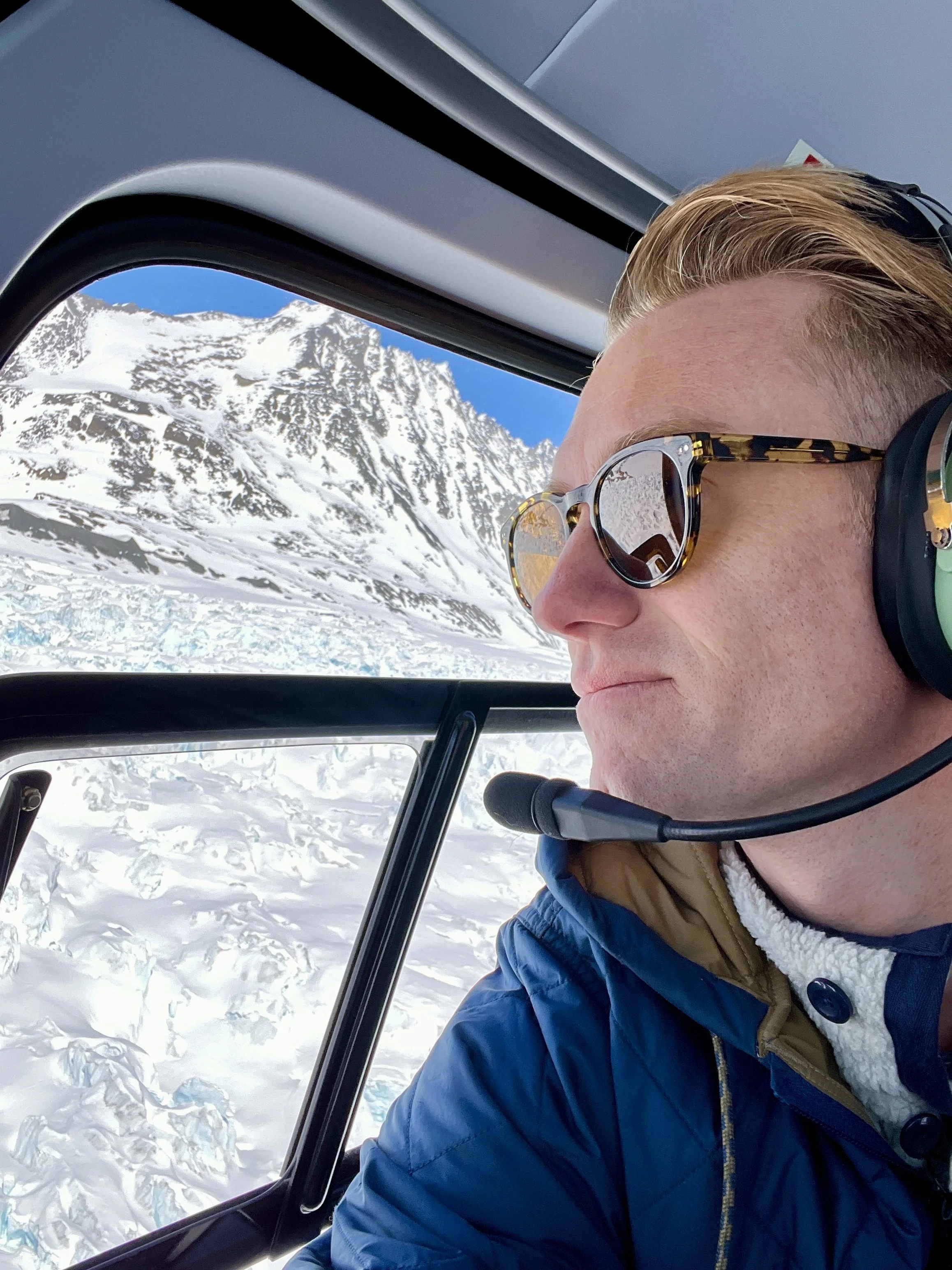Chase Cain NBC Meteorologist looking out a window in a helicopter in Antarctica