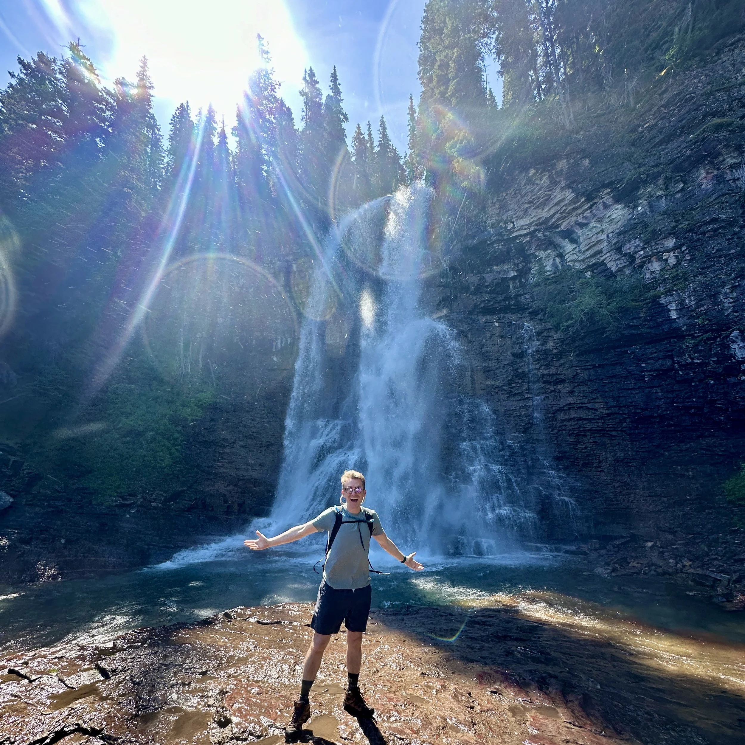 Chase Cain standing in front of a Waterfall in the Pacific Northwest.