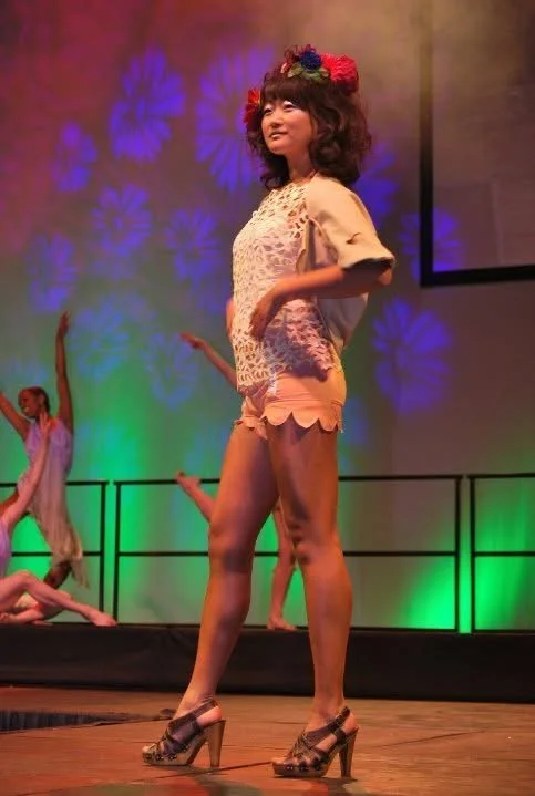 Jenny You wearing cowgirl electra shorts, bolero, and lace top in the Strut VCU fashion show.