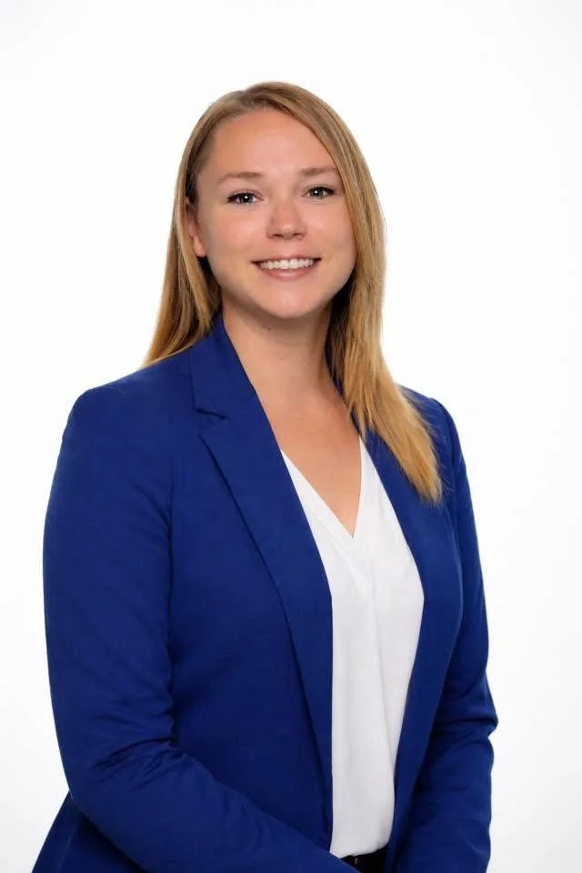 A woman with fair skin and blonde hair wearing a blue blazer and white top, smiling in front of a plain white background. Criminal Defense Attorney Fresno.