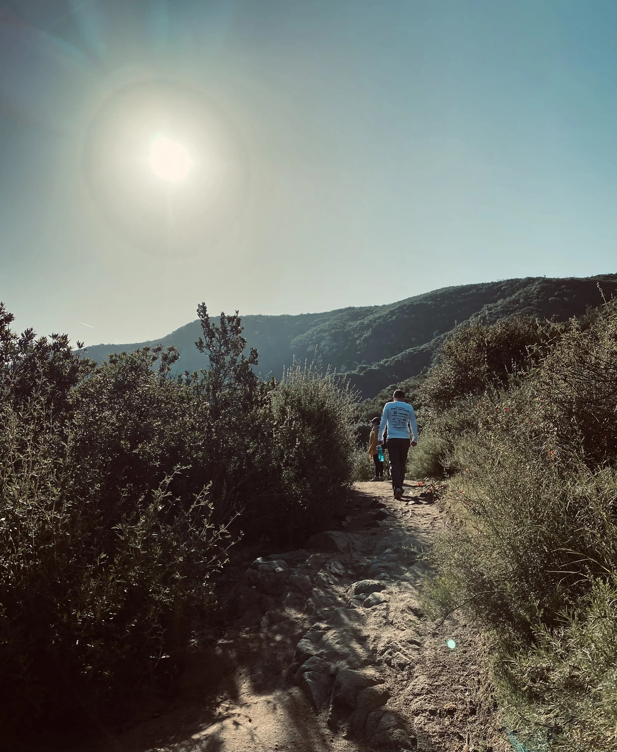 Photo of a woman walking through a winding trail in the mountains