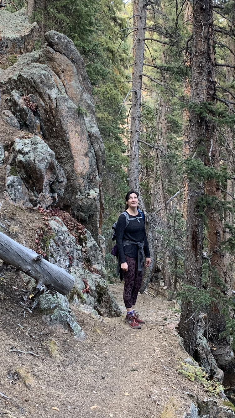 Photo of Evie on a train, dressed for hiking