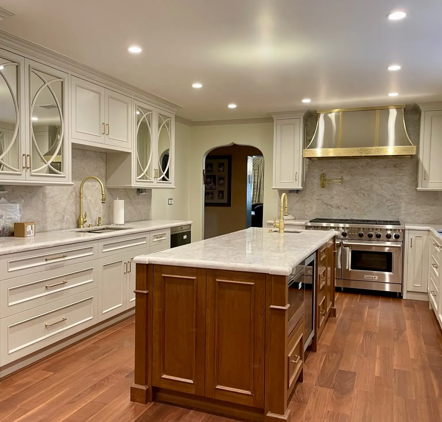 Luxury Hancock Park traditional kitchen with quartzite countertops, walnut island, custom white cabinetry, and stainless steel and brass range hood in a classic Los Angeles home.