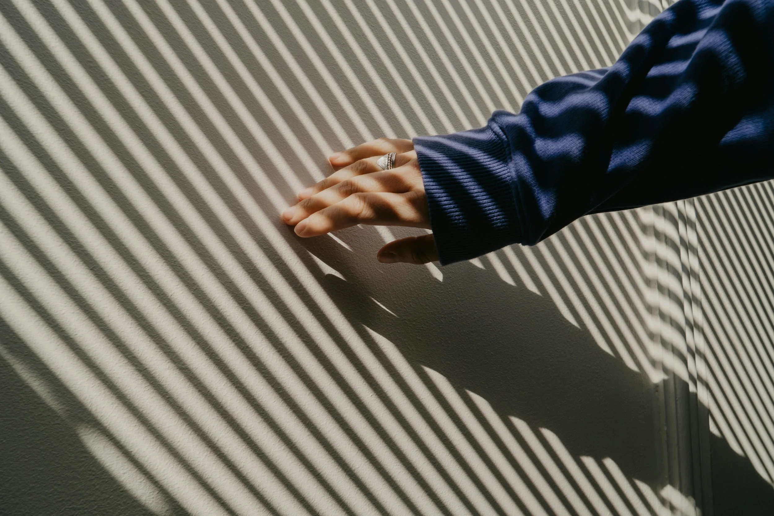 Hand touching wall material detail light and shadow interior