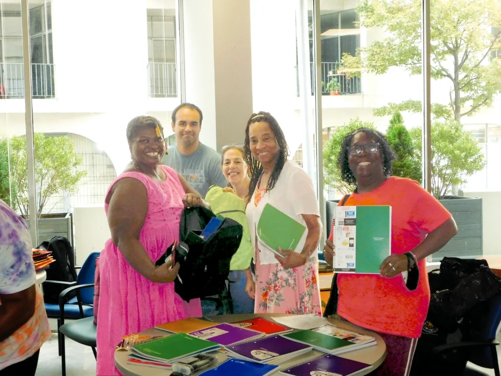 A group of members work together to prepare for a free-of-charge Benefit Program distribution of school supplies, one of the self-help benefits available to members.