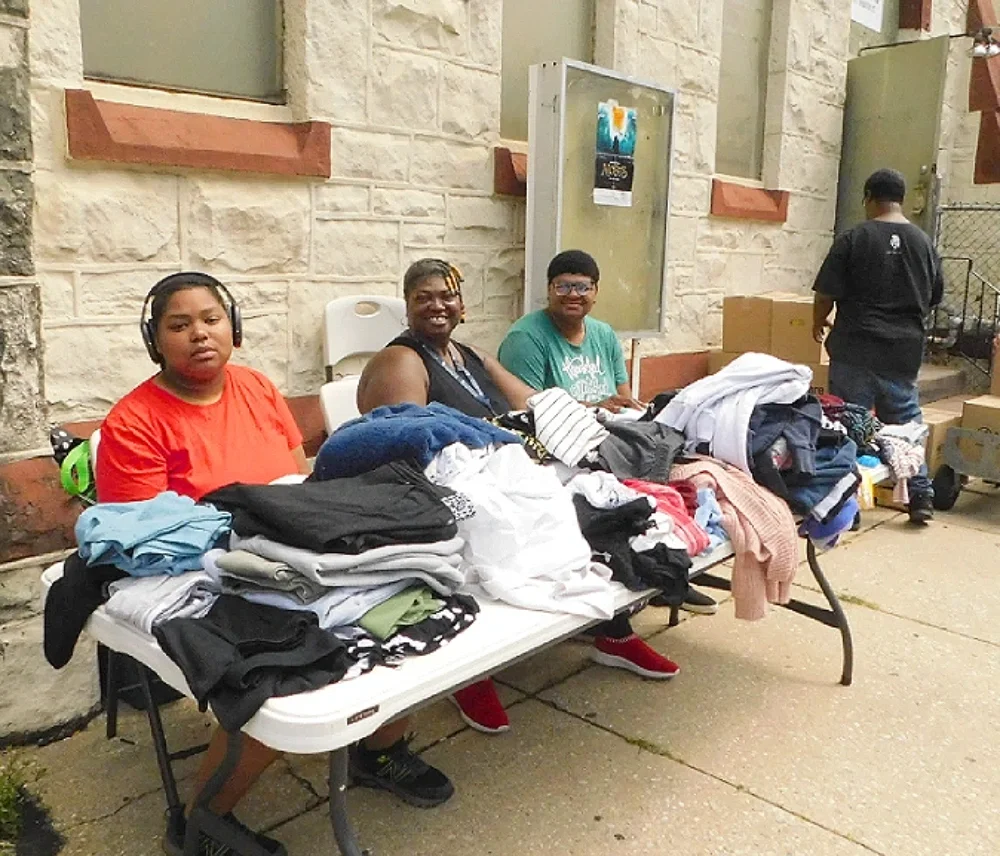 Members man a table of clothing for an ESWA clothing distribution to members