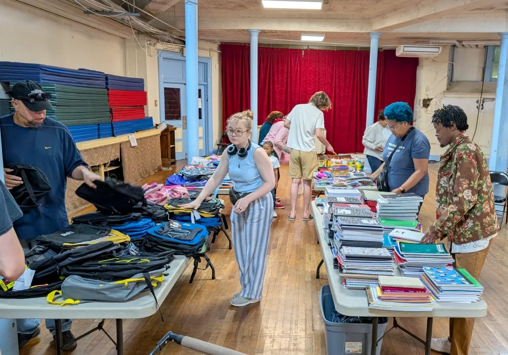 ESWA volunteers and members sort and pack a room full of Back to School supplies for the distribution to membership families as part of ESWA's budget saving program