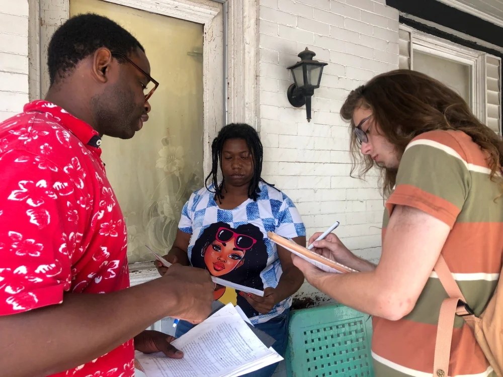 A canvass on a  summer day , two ESWA volunteers sign up a new member on her porch