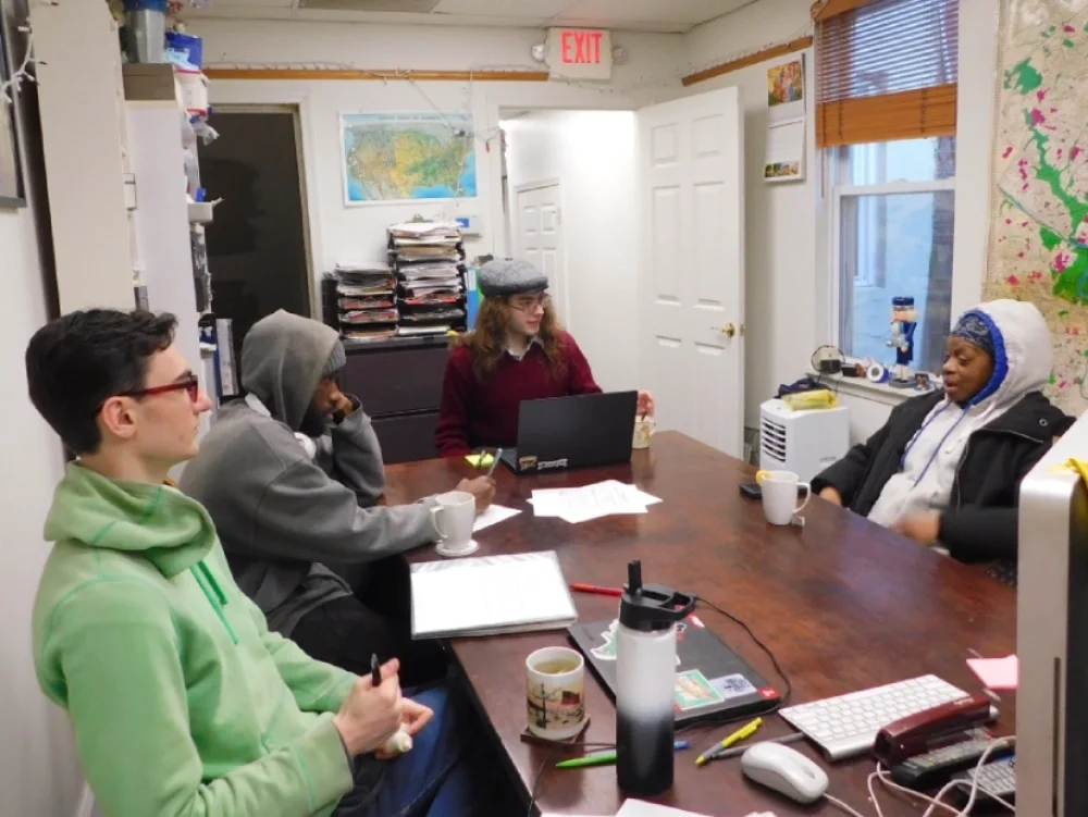 An ESWA Benefit Advocate interviews a member needing assistance and provides advocacy training to two other volunteers