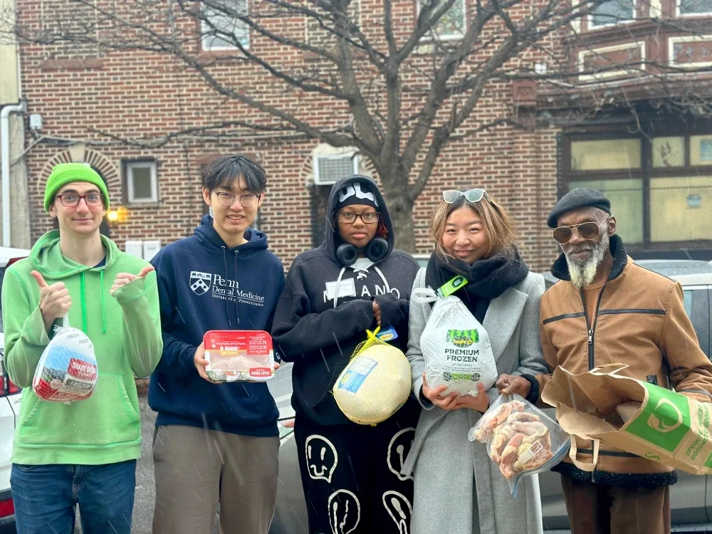Volunteers holding frozen turkeys for Thanksgiving distribution.