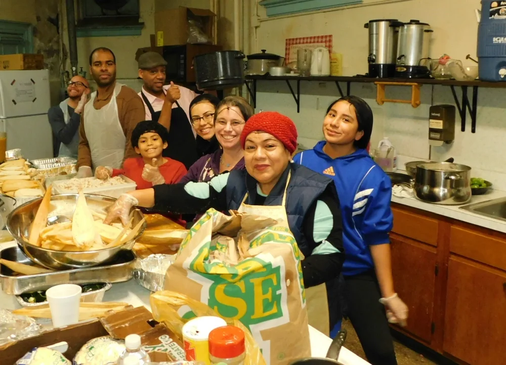 A group of members and volunteers in a church kitchen prepare tamales for the annual Super Bowl Tamale Benefit.