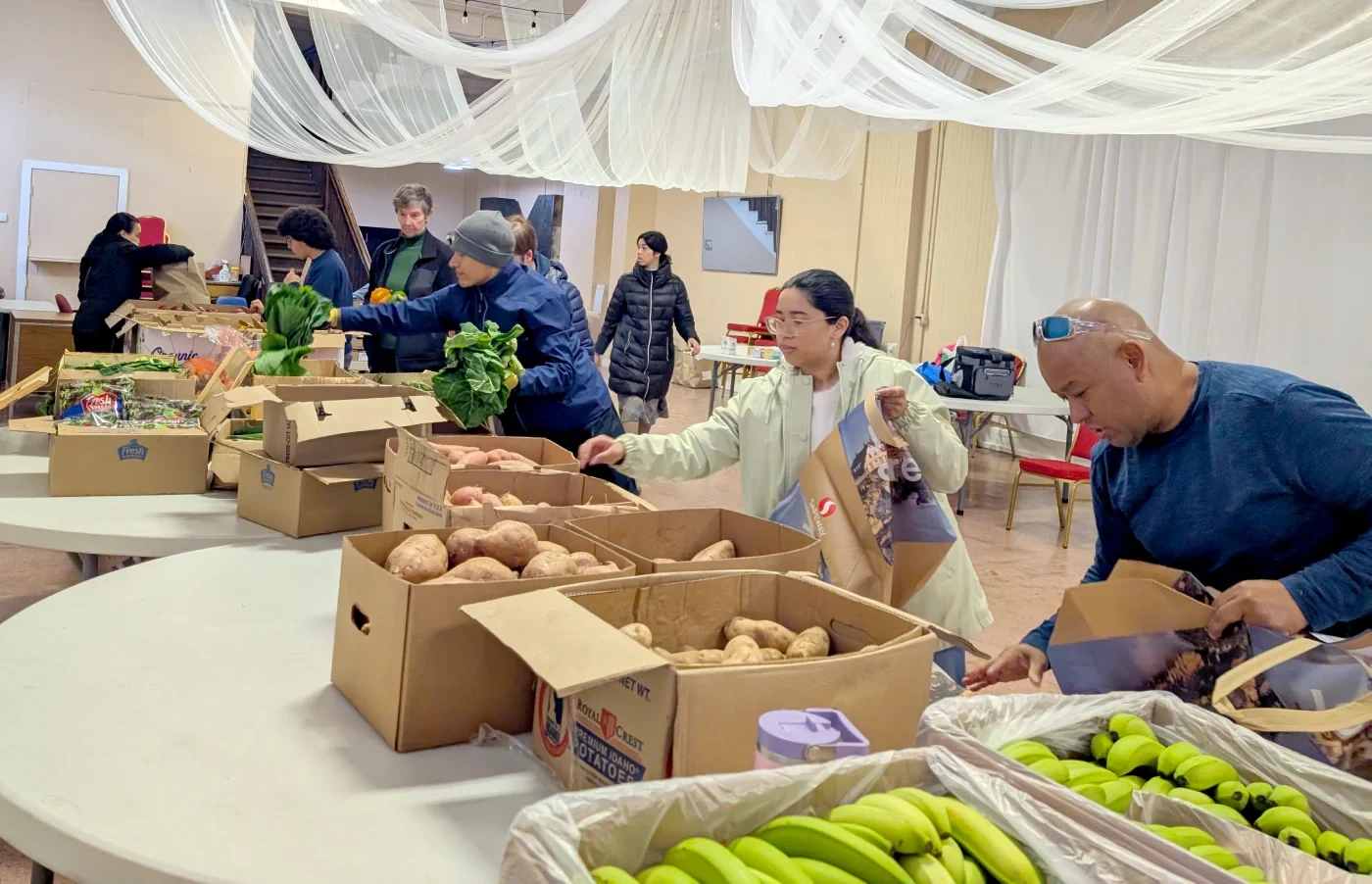 ESWA volunteers and members sorting and packing produce for the weekly food distribution to members