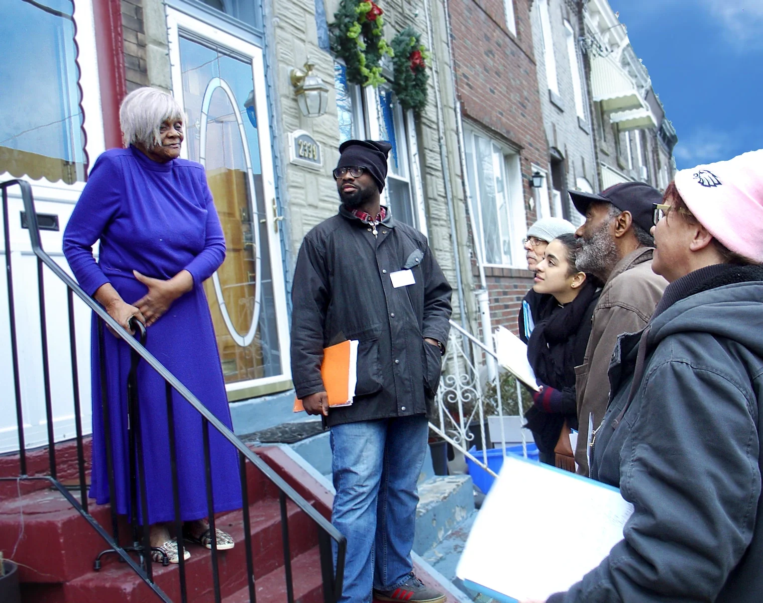 Five ESWA volunteers listen to an ESWA member wearing a blue dress