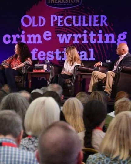 Panel of three speakers on stage at the Old Peculier Crime Writing Festival, with an audience in front.