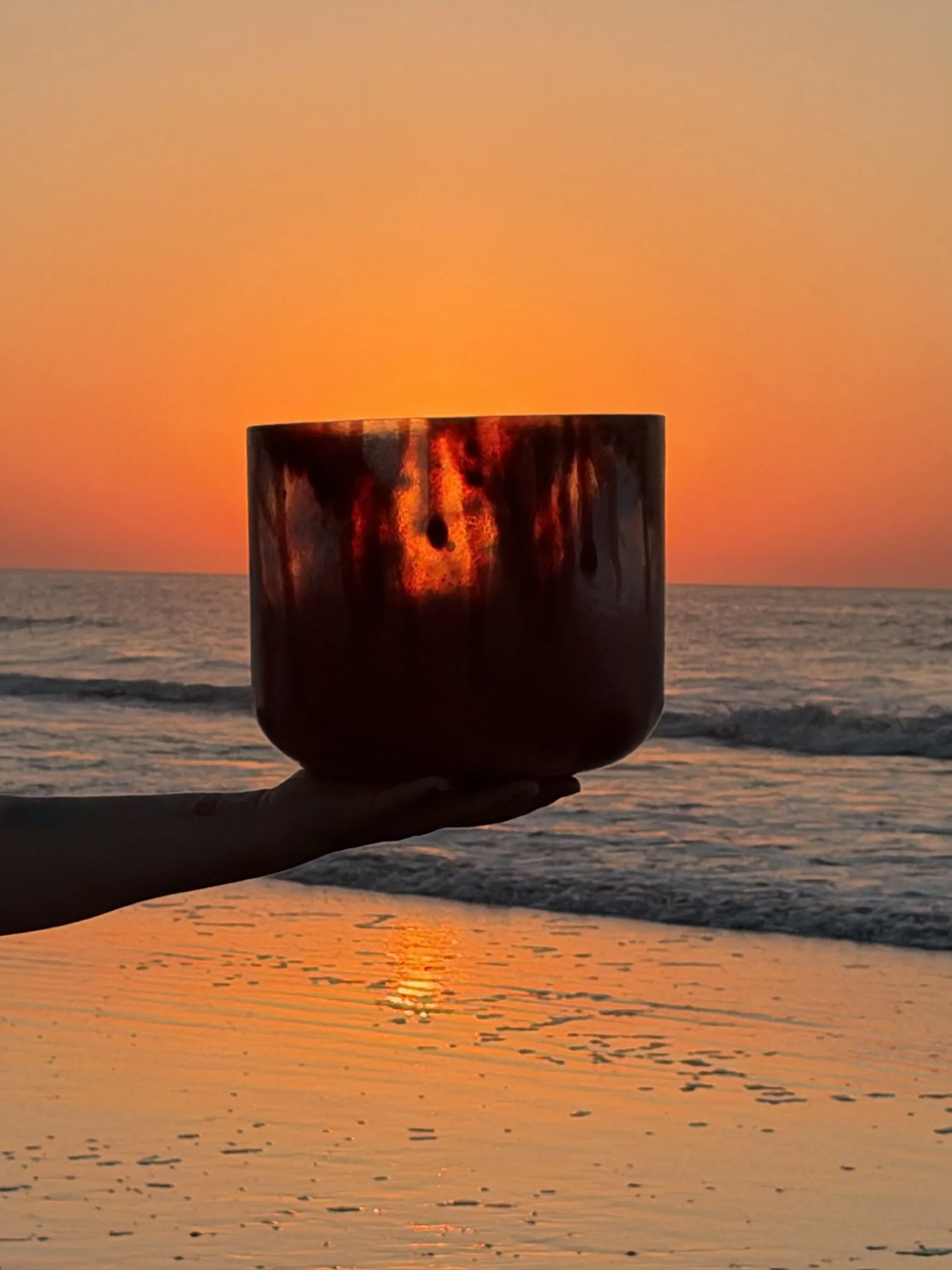 Dragon’s Blood Tree Resin infused quartz singing bowl glowing red in the sunrise.