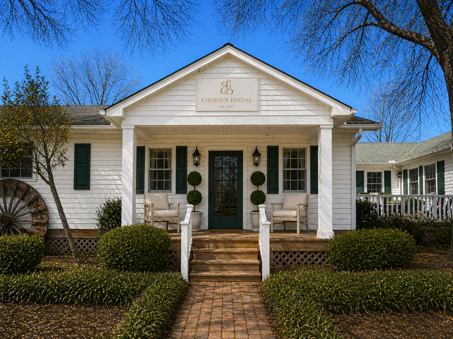White house with front porch, green shutters, and a sign that reads 'Emersyn Bridal' with the year 2026, surrounded by trees and landscaping.