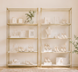 White shelves with plants and decorative items against a plain wall.