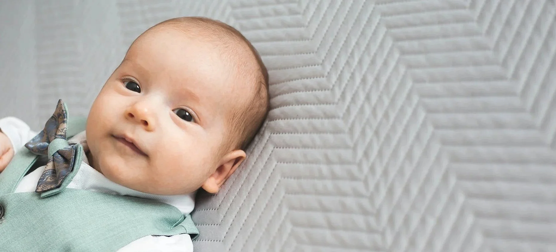 baby lay down in green outfit