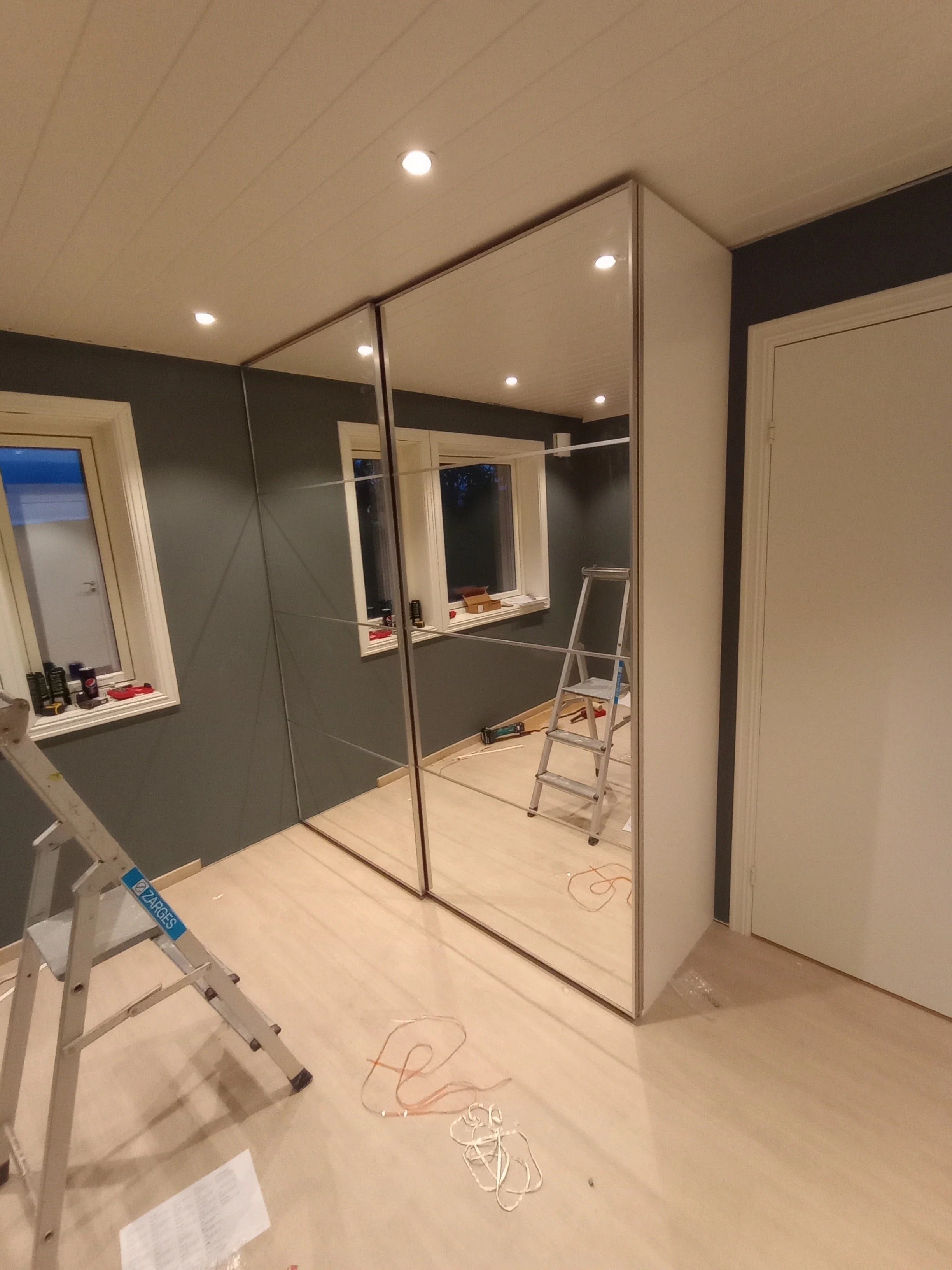Moderne skyvedørsgarderobe med speilfronter som gir mer lys og en følelse av større rom. Løsningen kombinerer praktisk oppbevaring med et stilrent og elegant uttrykk.