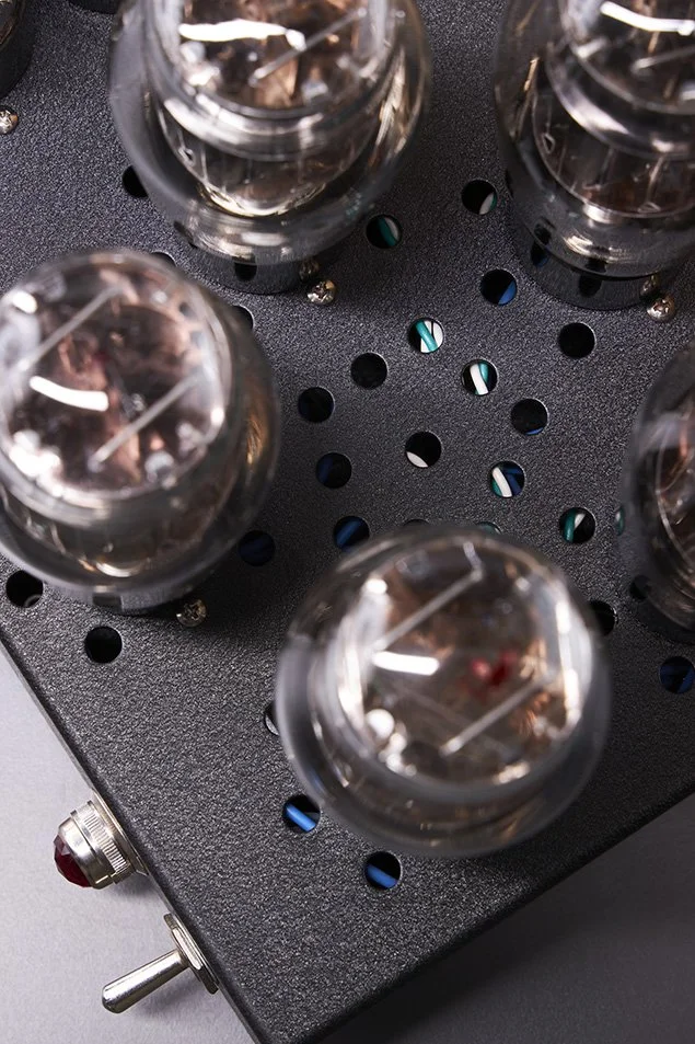 Elektronenröhre in einem Vintage-Röhrenverstärker, aus schwarzem Metall mit mehreren Röhren auf einer perforierten Oberfläche.