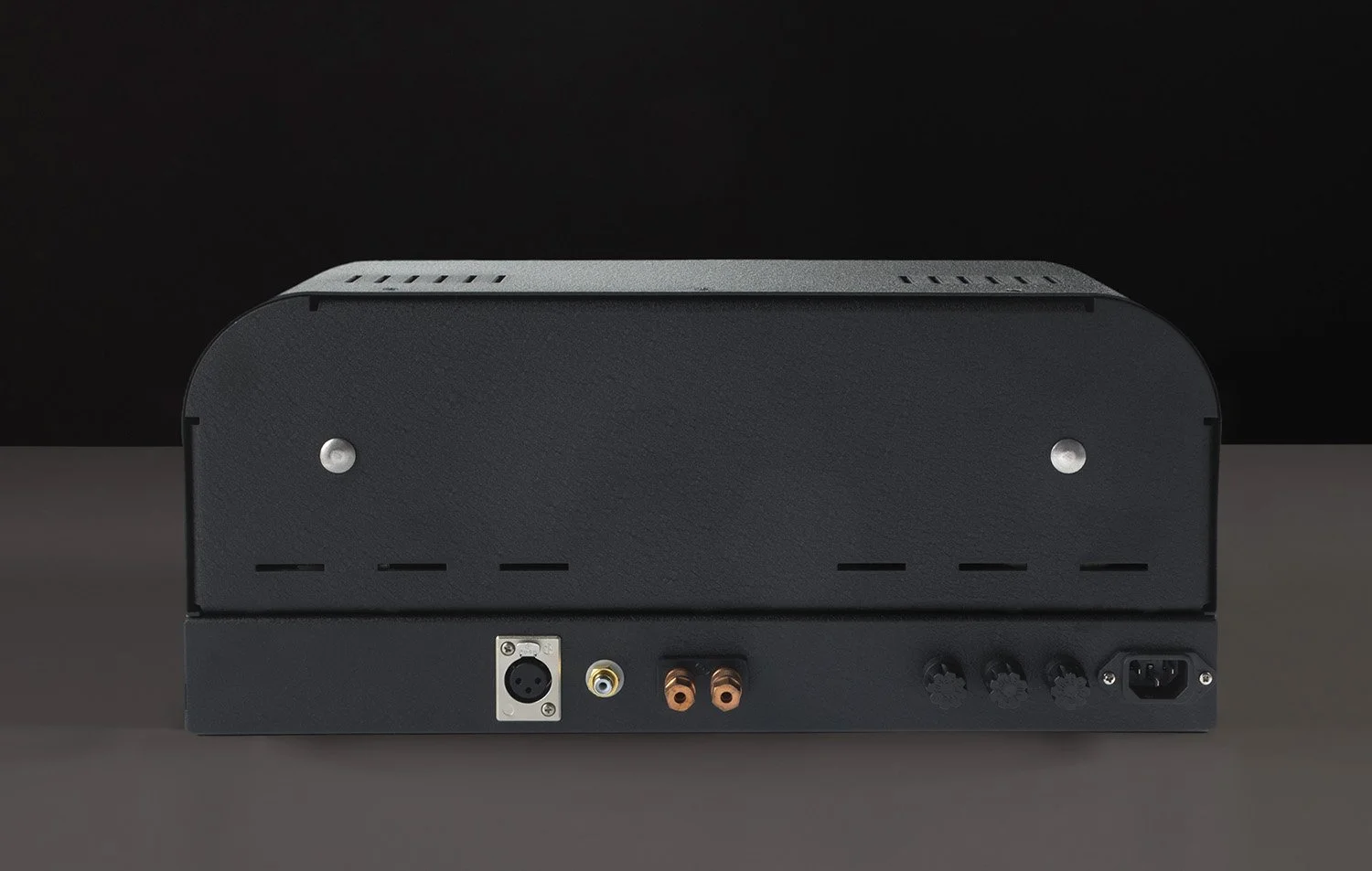 Rückseite eines schwarzen Audioverstärkers mit mehreren Anschlussbuchsen, darunter XLR, Cinch, Speaker-Ausgänge und Netzanschluss