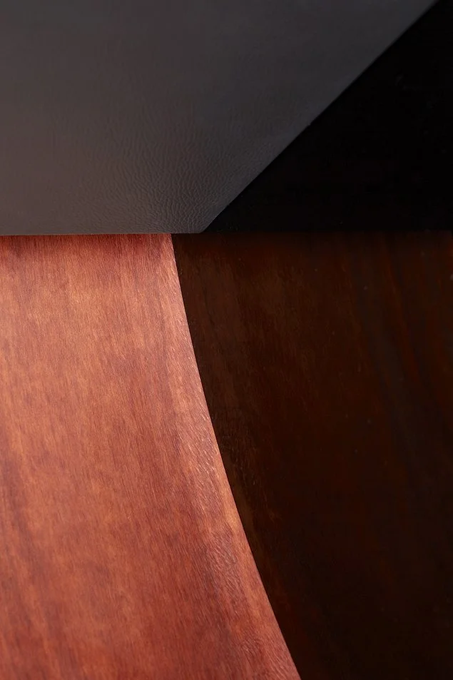 Nahaufnahme von drei unterschiedlich gefärbten Holzflächen, die aneinanderstoßen, mit sichtbaren Holzmaserungen.