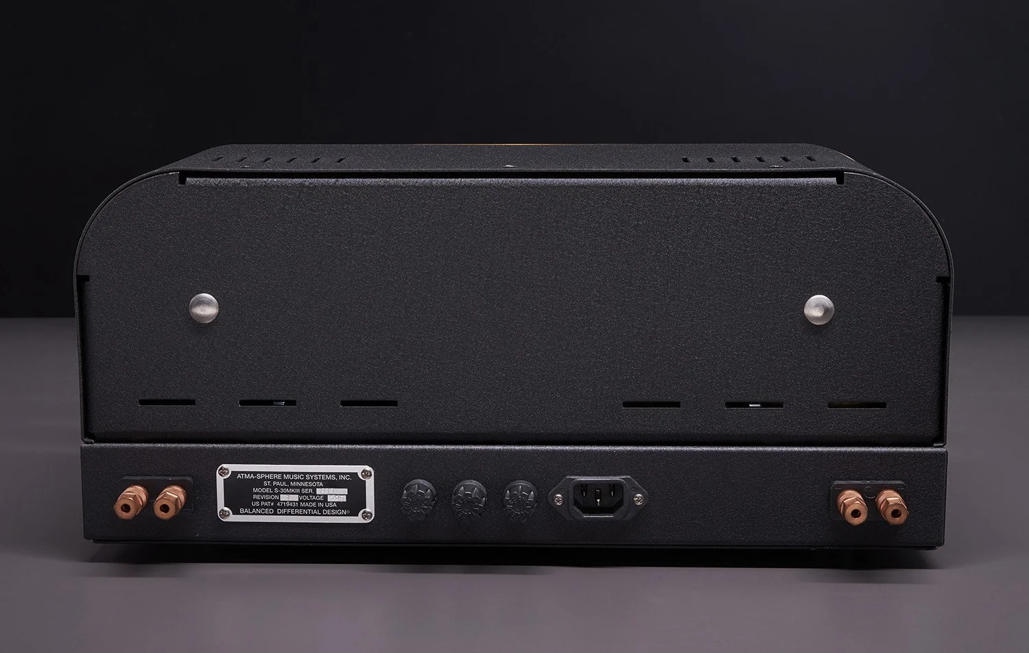 Rückseite eines schwarzen Audioverstärkers mit Anschlüssen und einem Label.