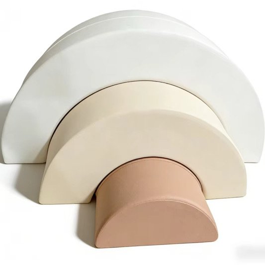 Three semicircular objects in different sizes and colors arranged from largest to smallest, in white, cream, and pink.