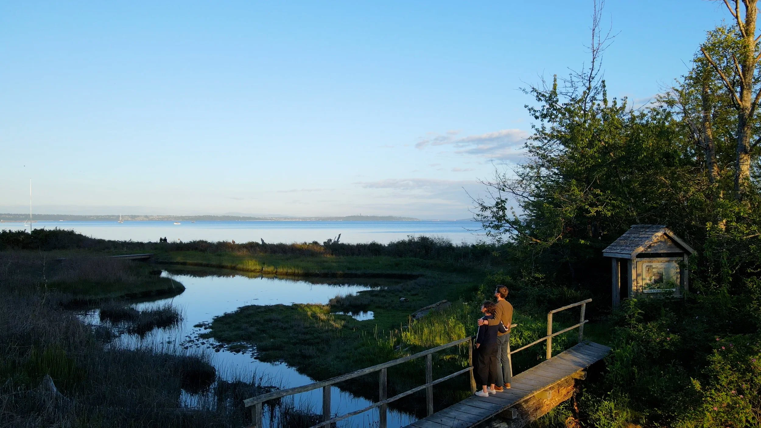Landscape view of the Puget Sound with couple embracing on a walking bridge