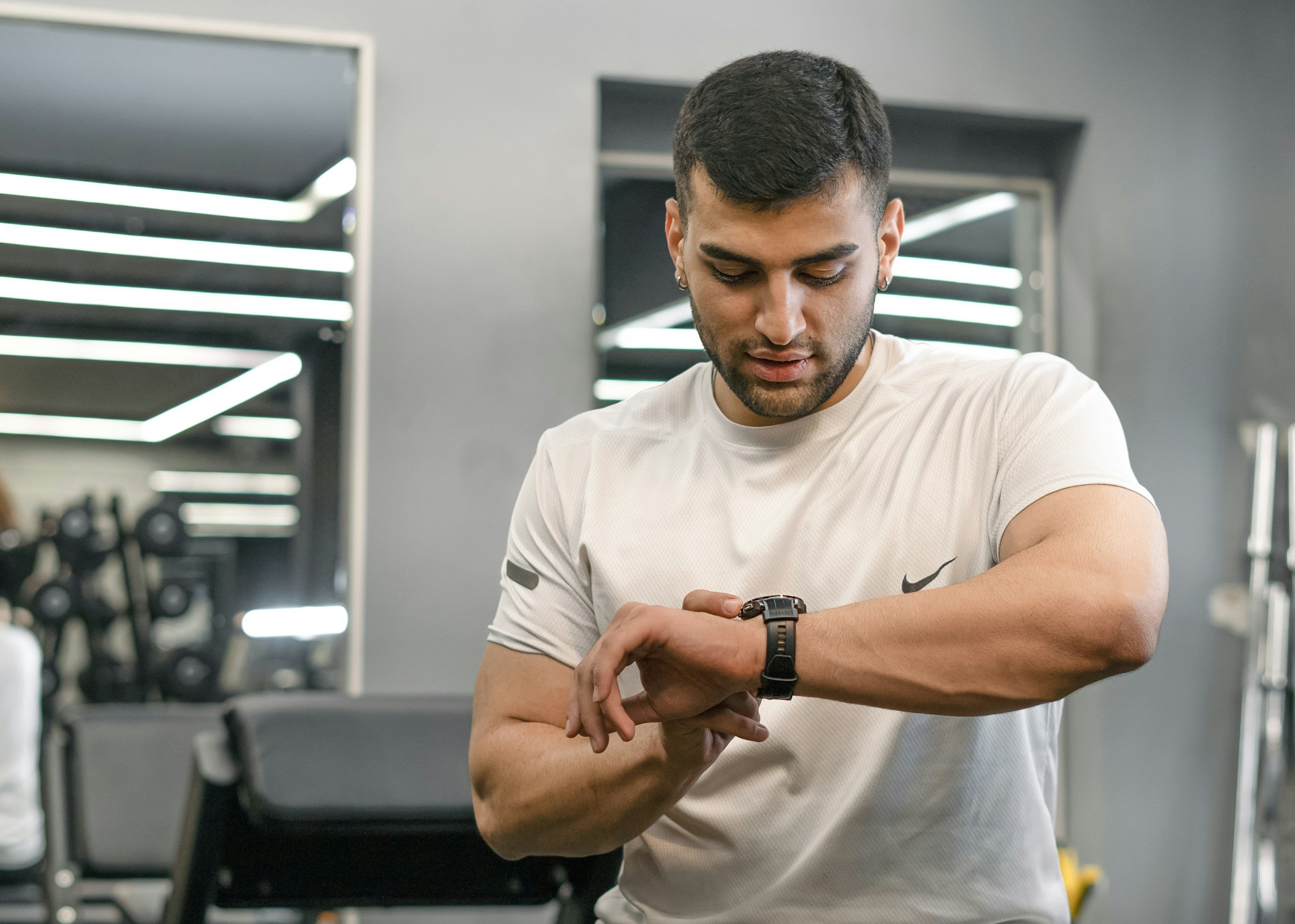 A man checking his watch in a gym