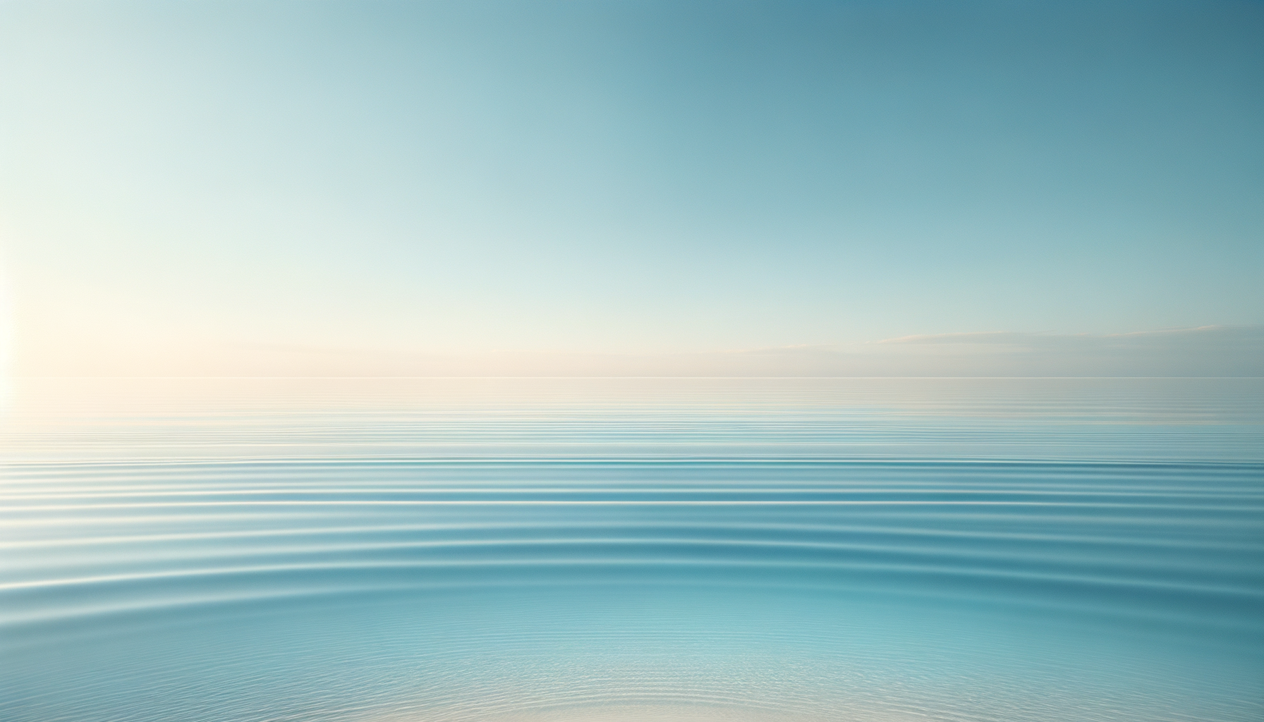 Calm ocean with gentle ripples and a clear blue sky.