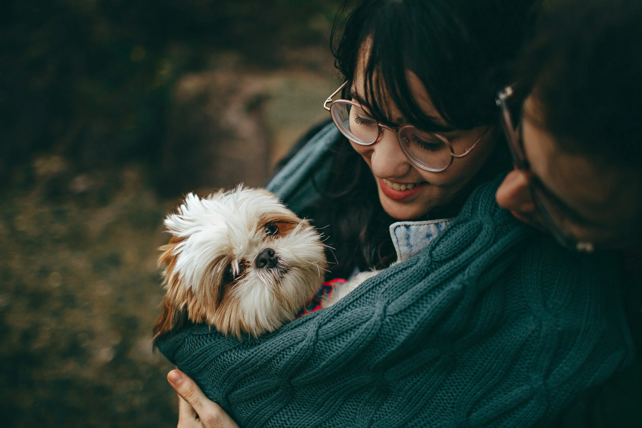 Couple smiling and holding therapy dog