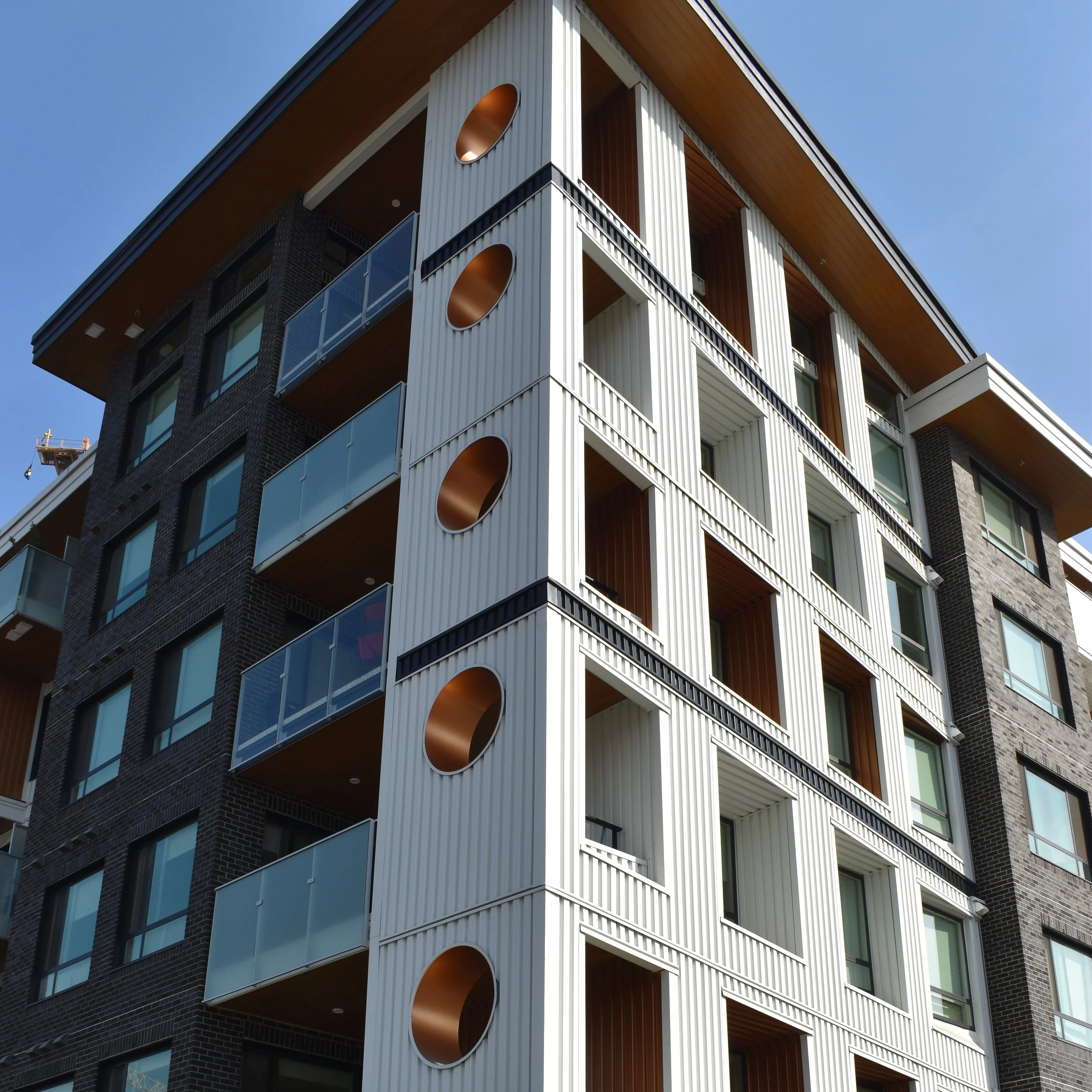 Mid-rise residential cladding installation in Vancouver using Hardie panels and siding by L2 Group