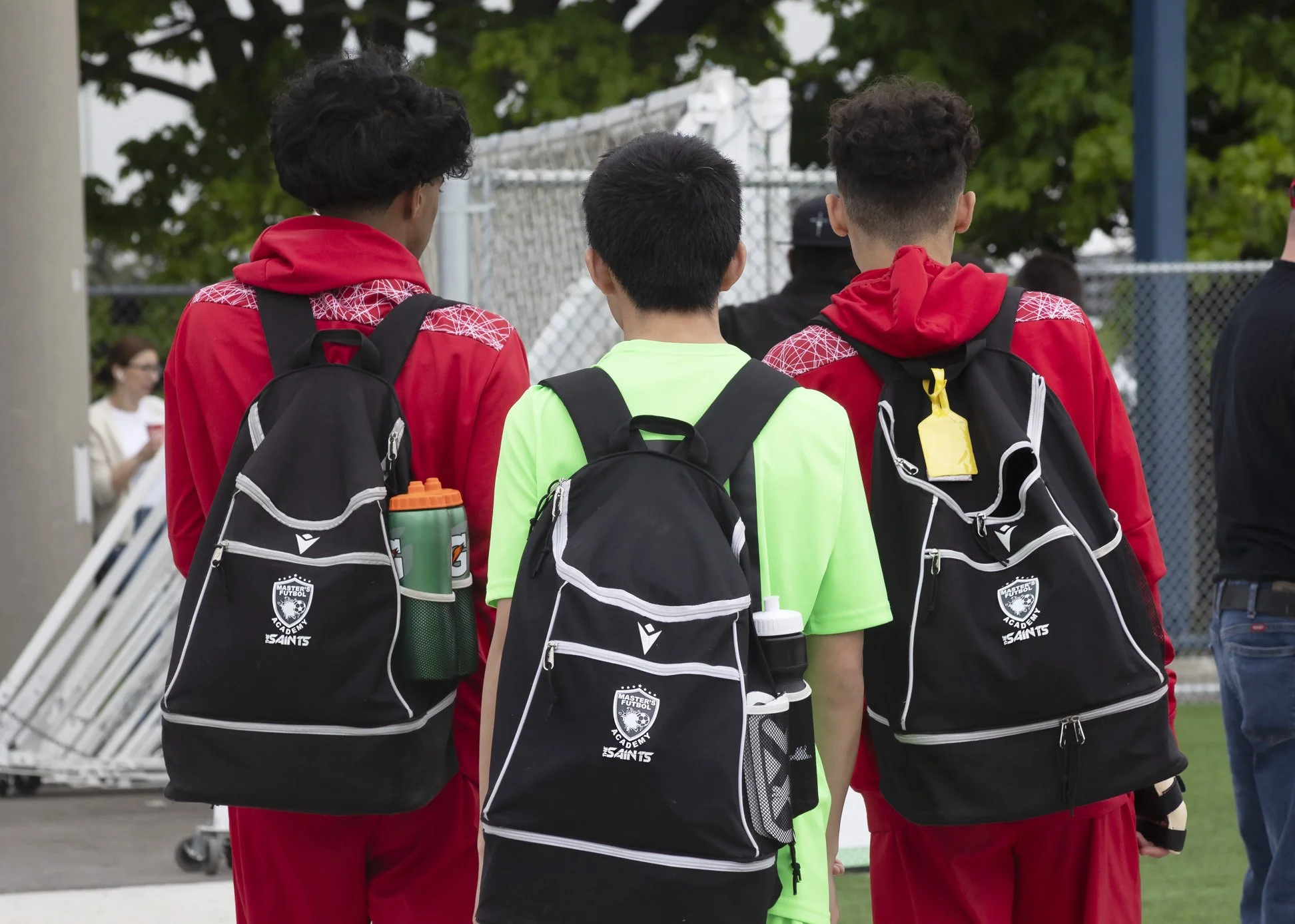 photograph of three soccer players after game taken from behind