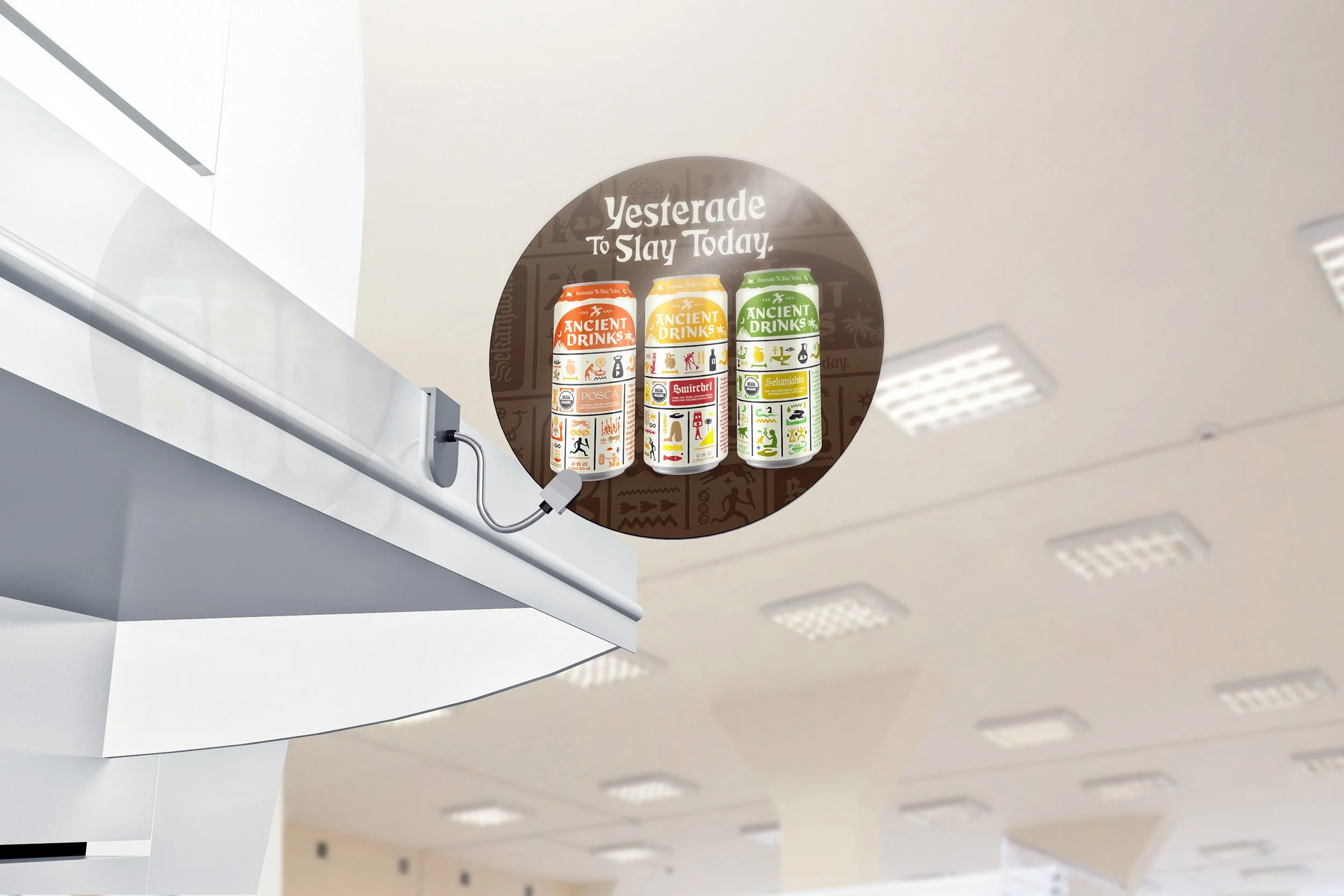 Can-sized beverages with old-world and cultural designs are displayed on a white shelf in an indoor setting with a white ceiling featuring recessed lighting and a wall with square acoustic panels.