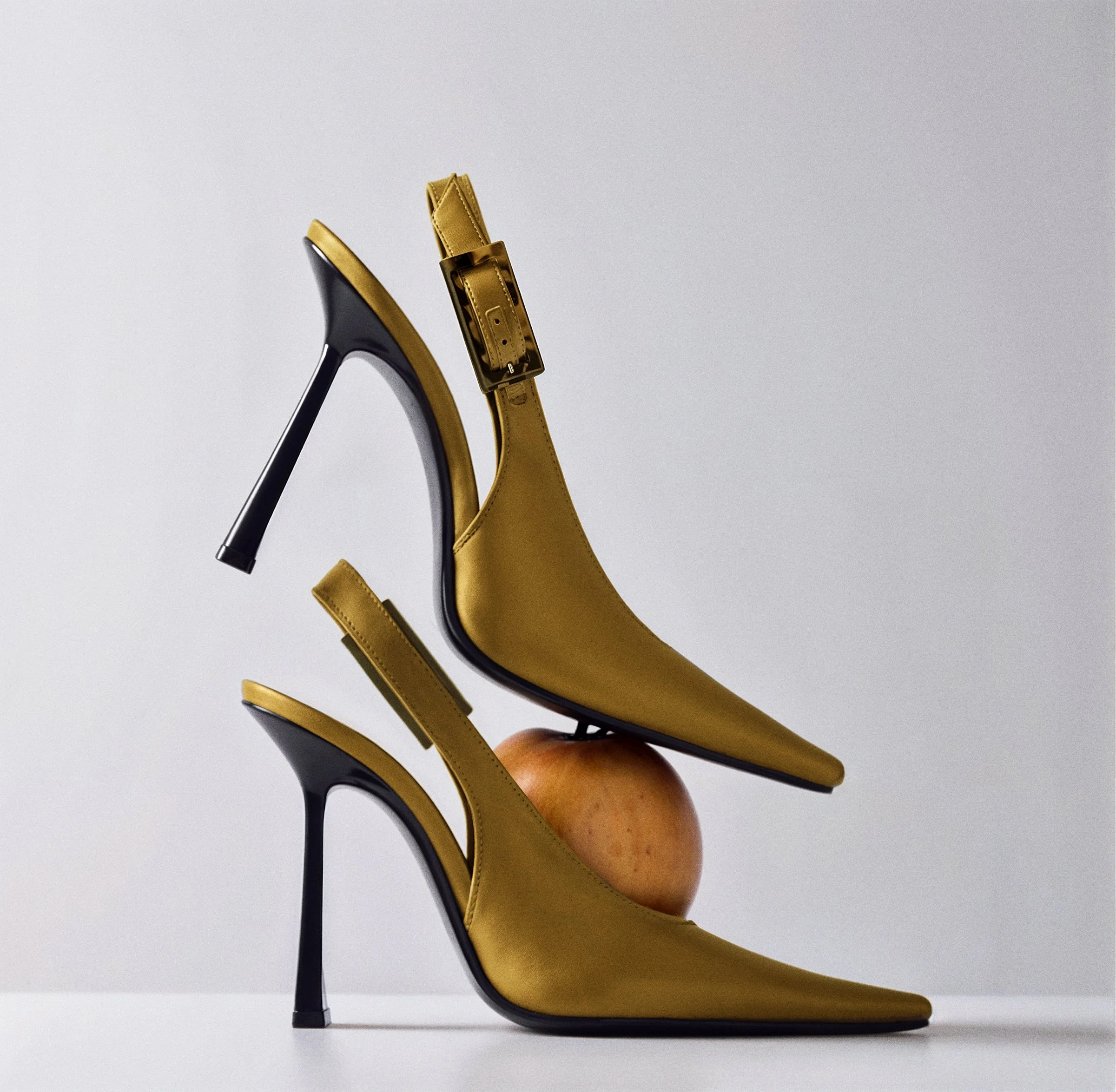 Close-up of a yellow high-heeled shoe with a black heel, displaying the shoe from a side profile.