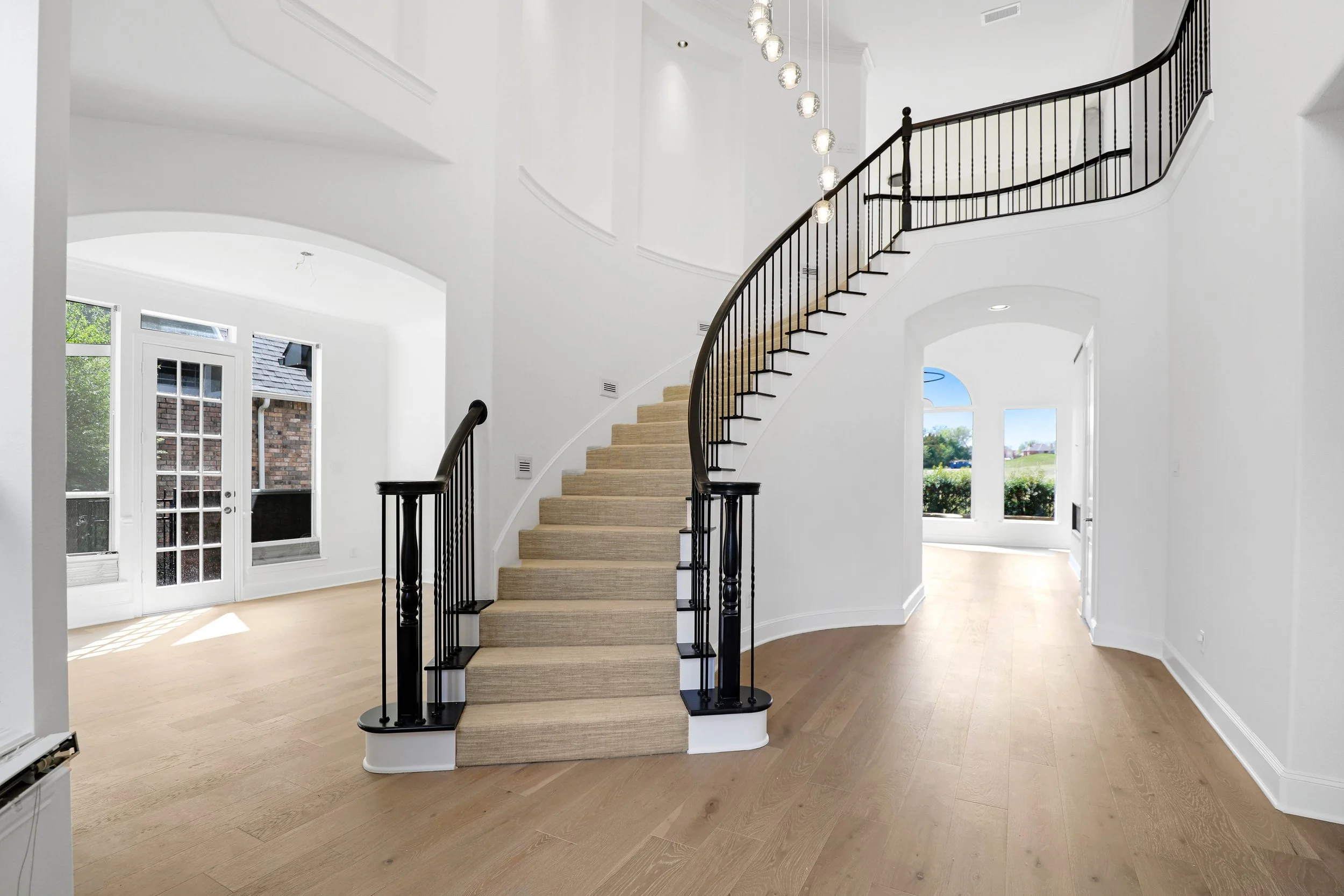 Custom Stair Installation – McKinney, TX. Curved staircase finished with woven low-pile carpet for a clean, refined transition between levels while complementing the surrounding European white oak flooring.