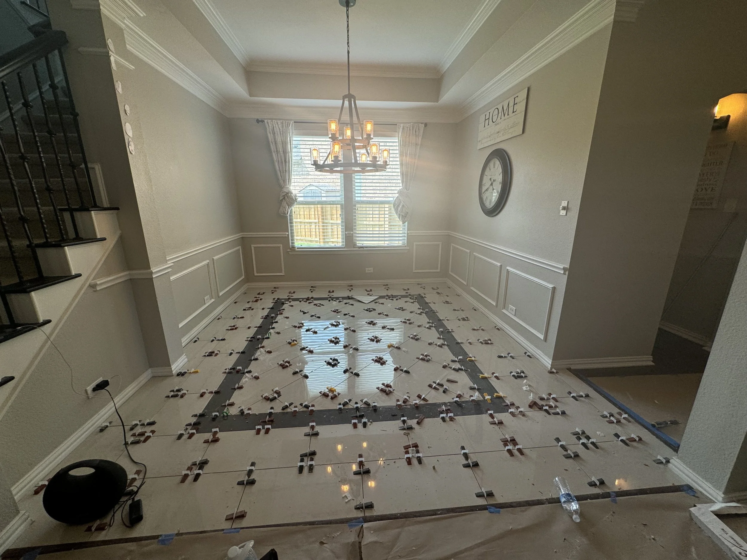 Custom Decorative Tile Floor – McKinney, TX. When the original engineered hardwood was discontinued, a custom tile design was created to complement the existing floors while adding an elegant focal point to the dining space.