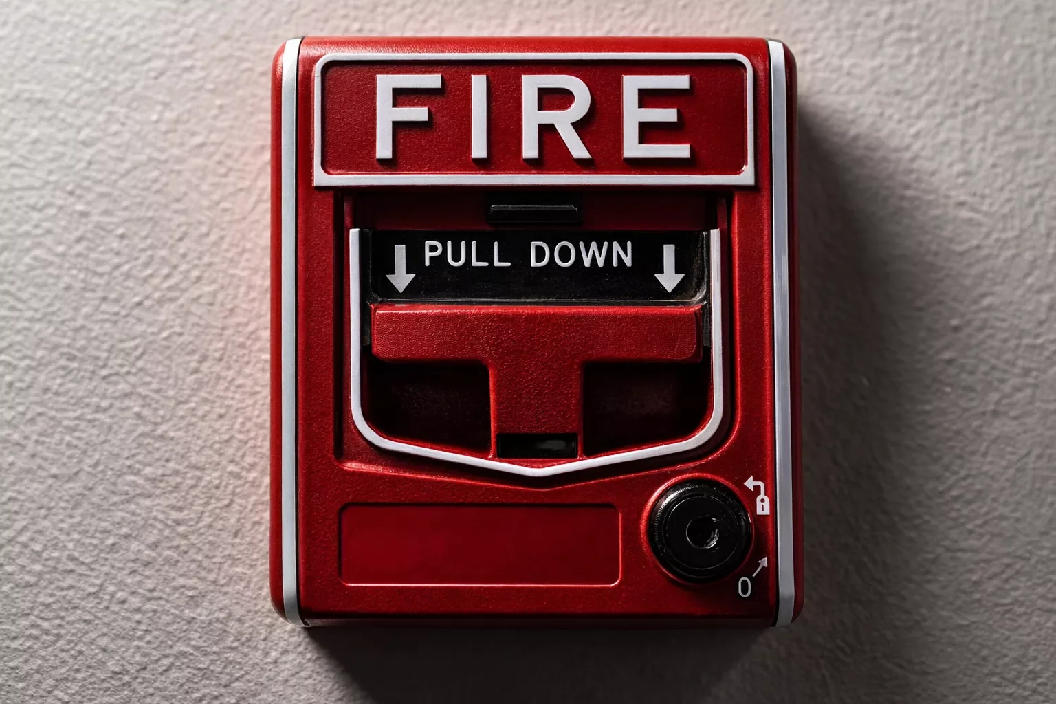 Red fire alarm with pull-down handle and instruction to pull down.