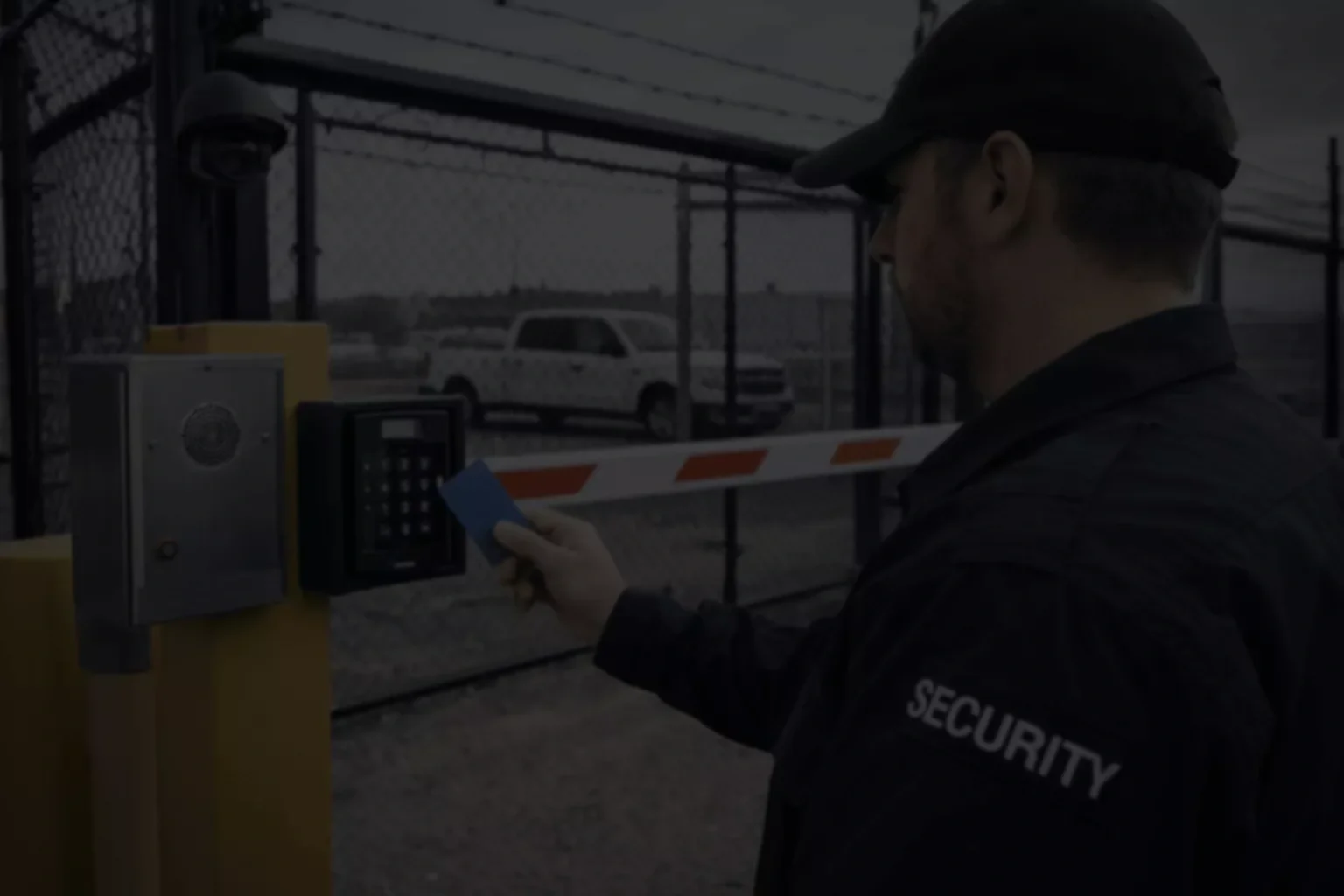 Security guard using a keypad access system at a gate