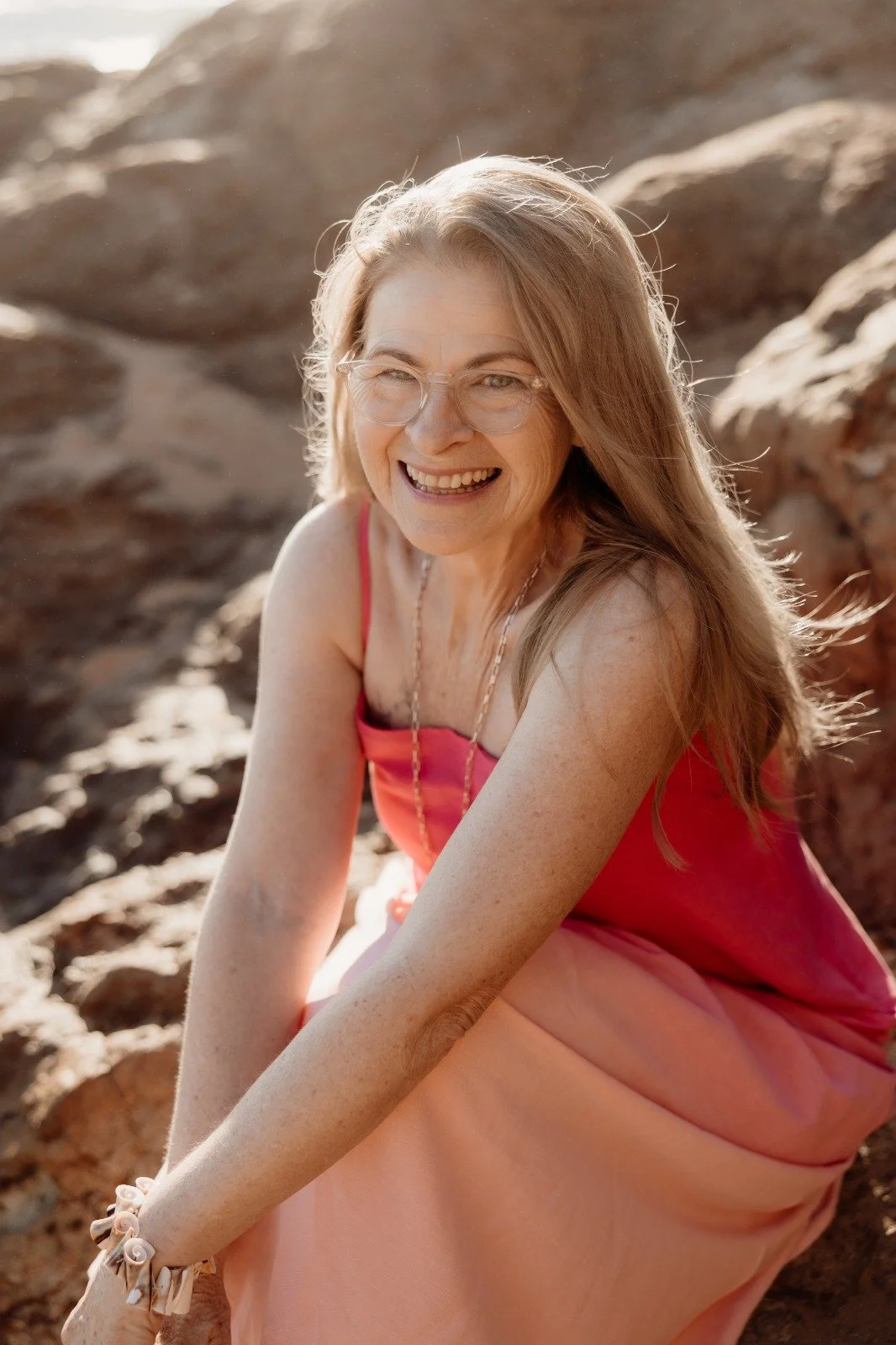 Headshot of OHTP student Carole wearing a pink dress at the beach